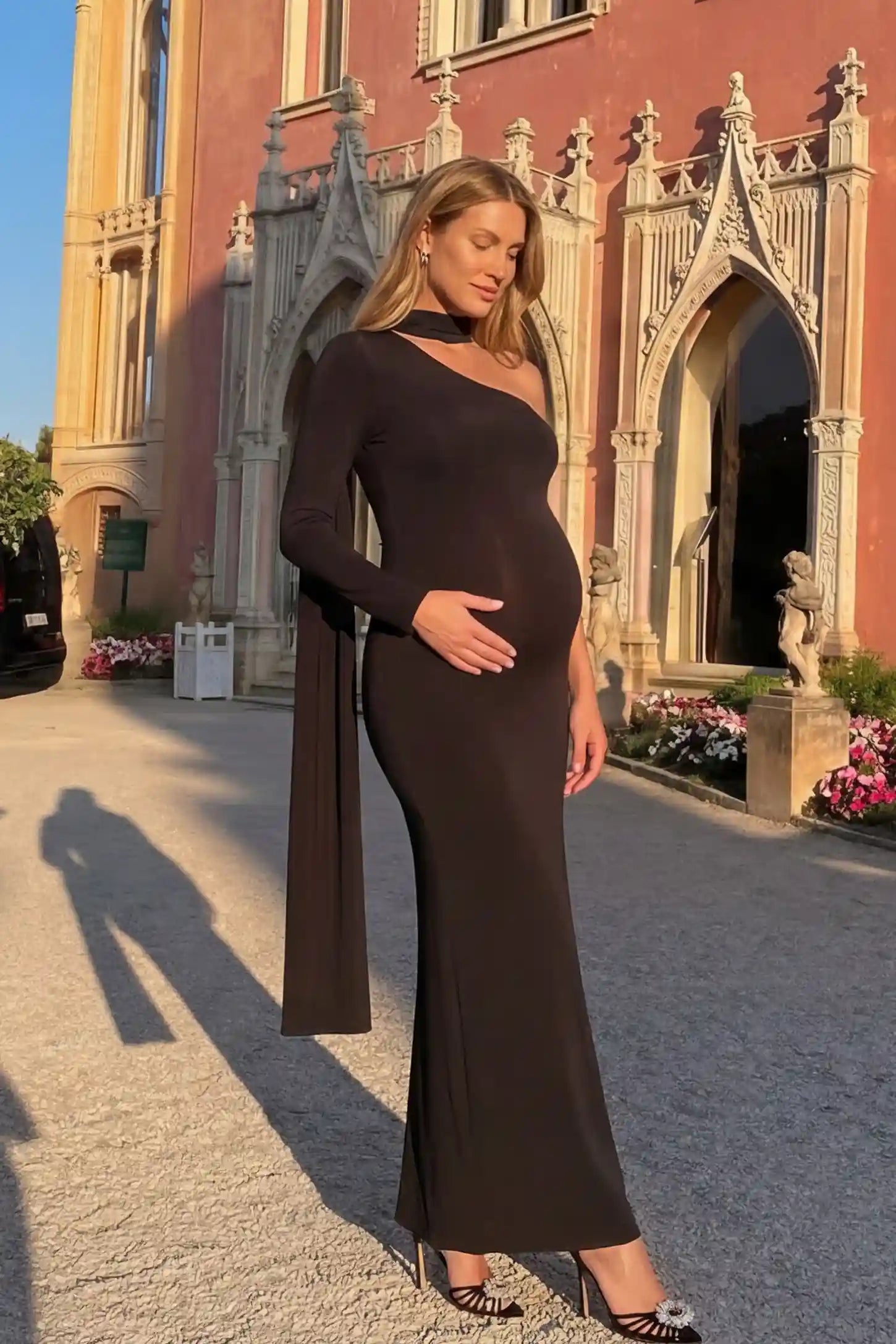 Soft Stretch One-Sleeve Halter Maternity Dress in Black featuring a luxury stretch finish on a pregnant model.