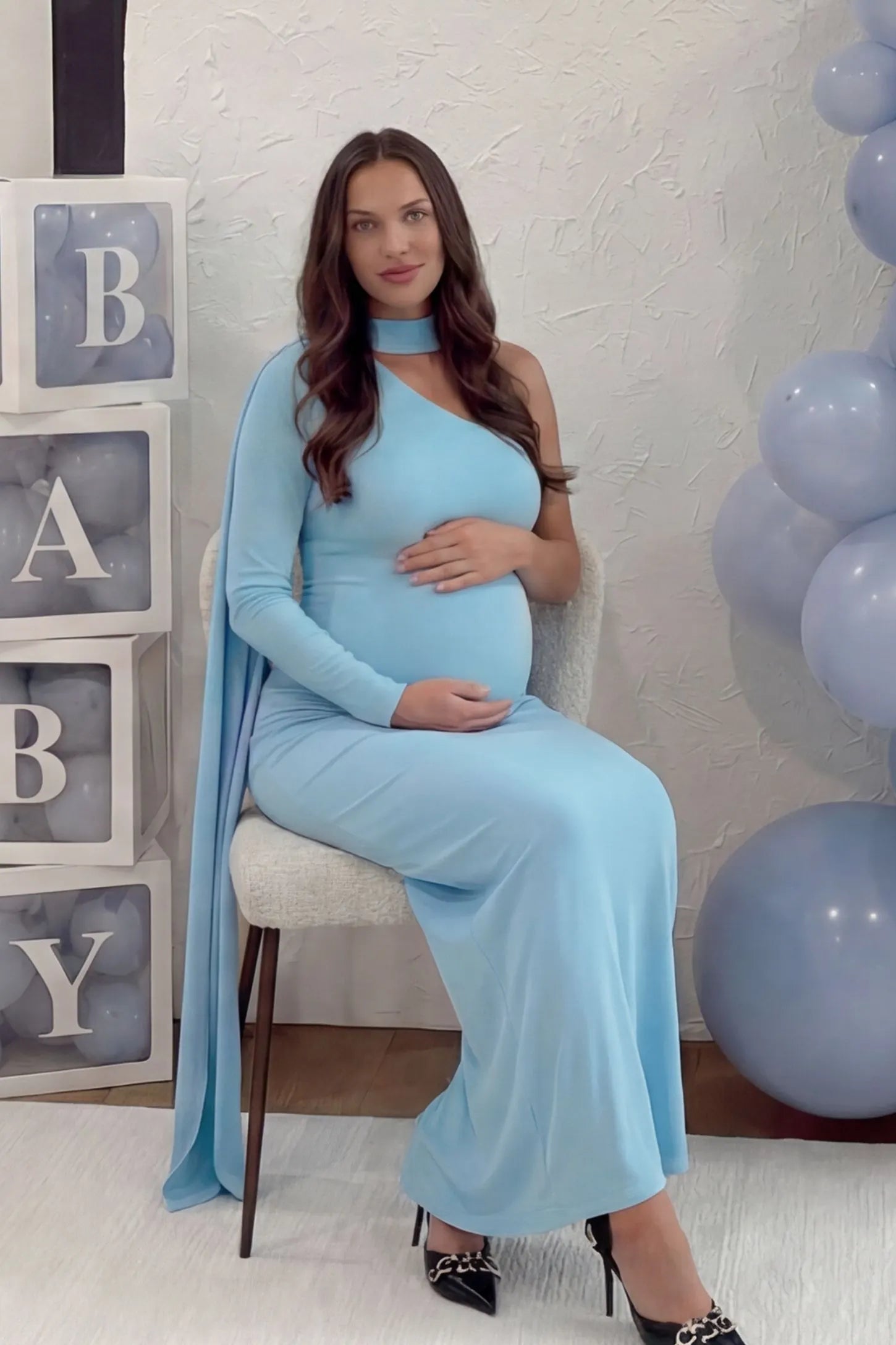 Soft Stretch One-Sleeve Halter Maternity Dress Soft Stretch One-Sleeve Halter Maternity Dress in Blue featuring a dramatic side cape on a pregnant model.