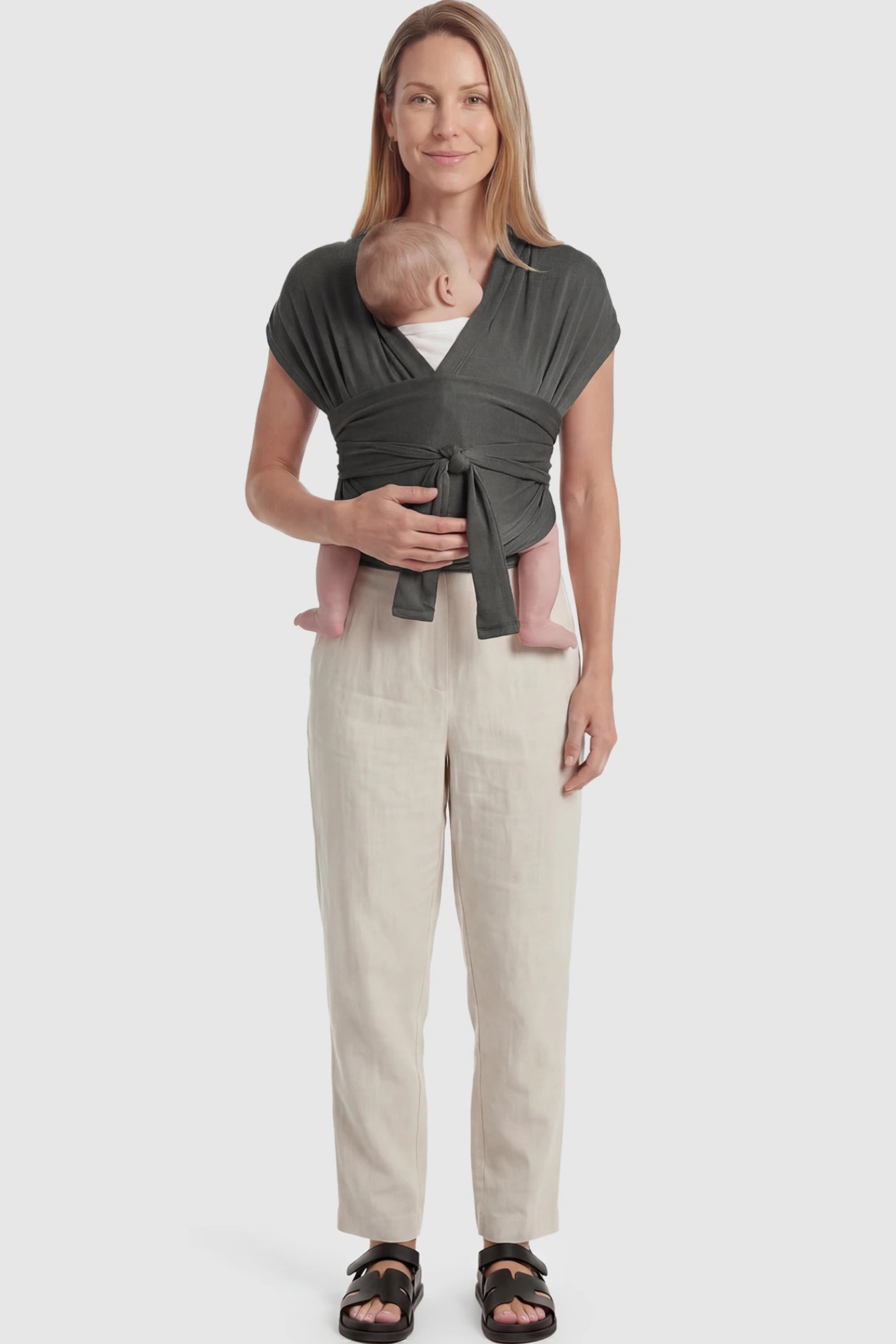 Soft Stretch Skin Friendly Baby Wrap Carrier Soft Stretch Skin Friendly Baby Wrap Carrier in Dark Gray featuring a secure front-tie knot on a mother holding her newborn showing full body.