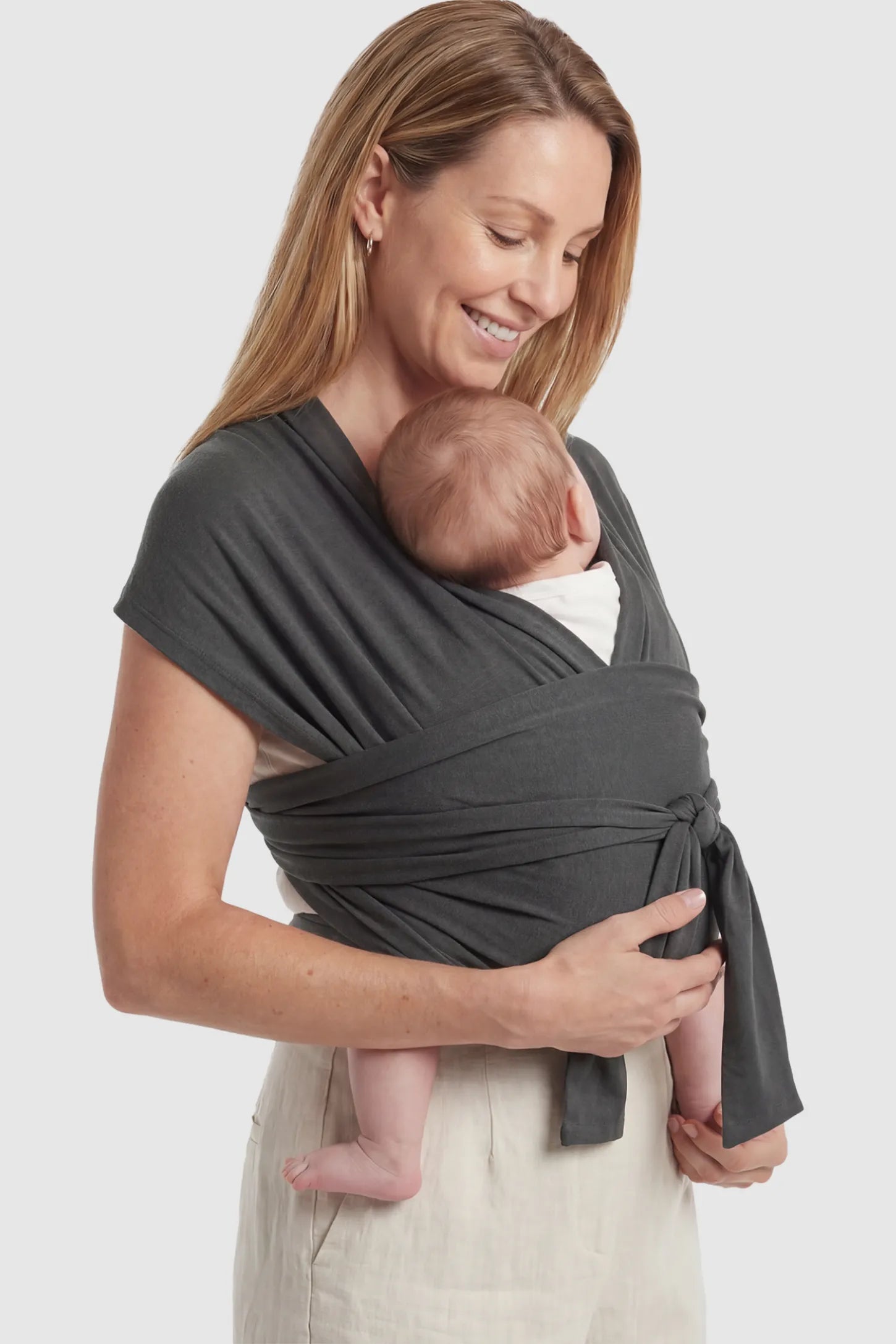 Soft Stretch Skin Friendly Baby Wrap Carrier Soft Stretch Skin Friendly Baby Wrap Carrier in Dark Gray featuring a secure front-tie knot on a mother holding her newborn showing side.