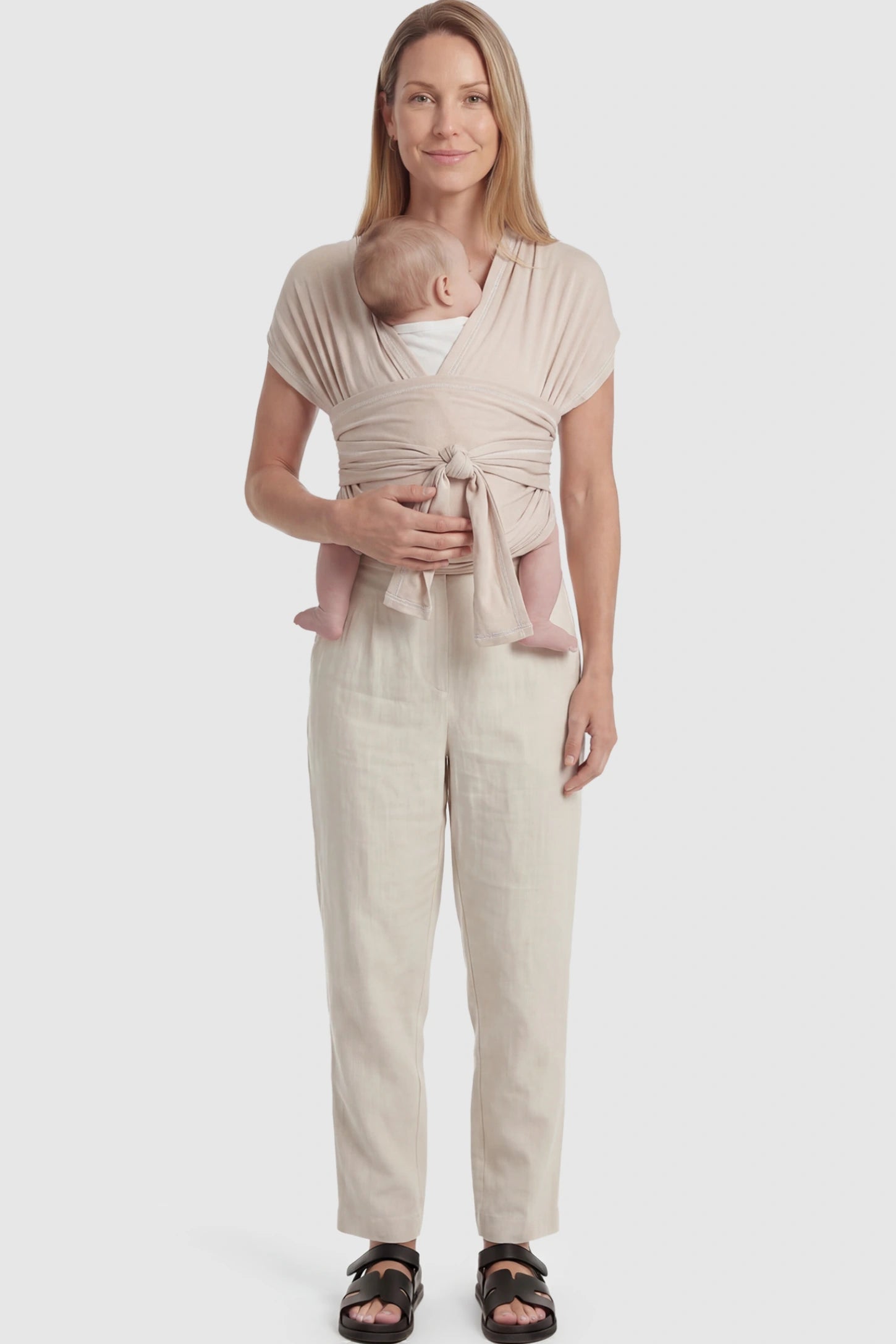 Soft Stretch Skin Friendly Baby Wrap Carrier Soft Stretch Skin Friendly Baby Wrap Carrier in Khaki featuring a secure front-tie knot on a mother holding her newborn showing full body.