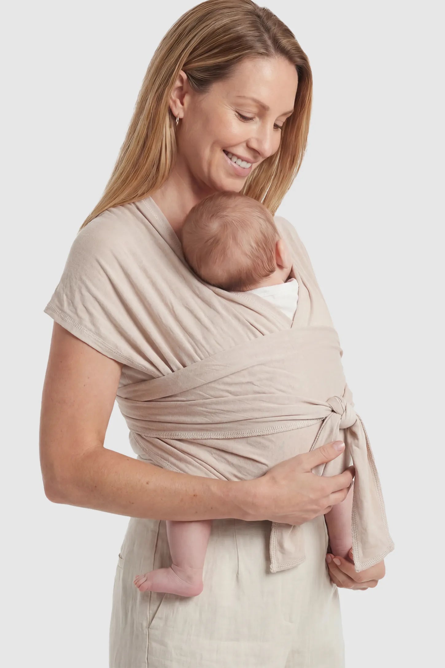 Soft Stretch Skin Friendly Baby Wrap Carrier Soft Stretch Skin Friendly Baby Wrap Carrier in Khaki featuring a secure front-tie knot on a mother holding her newborn showing side.