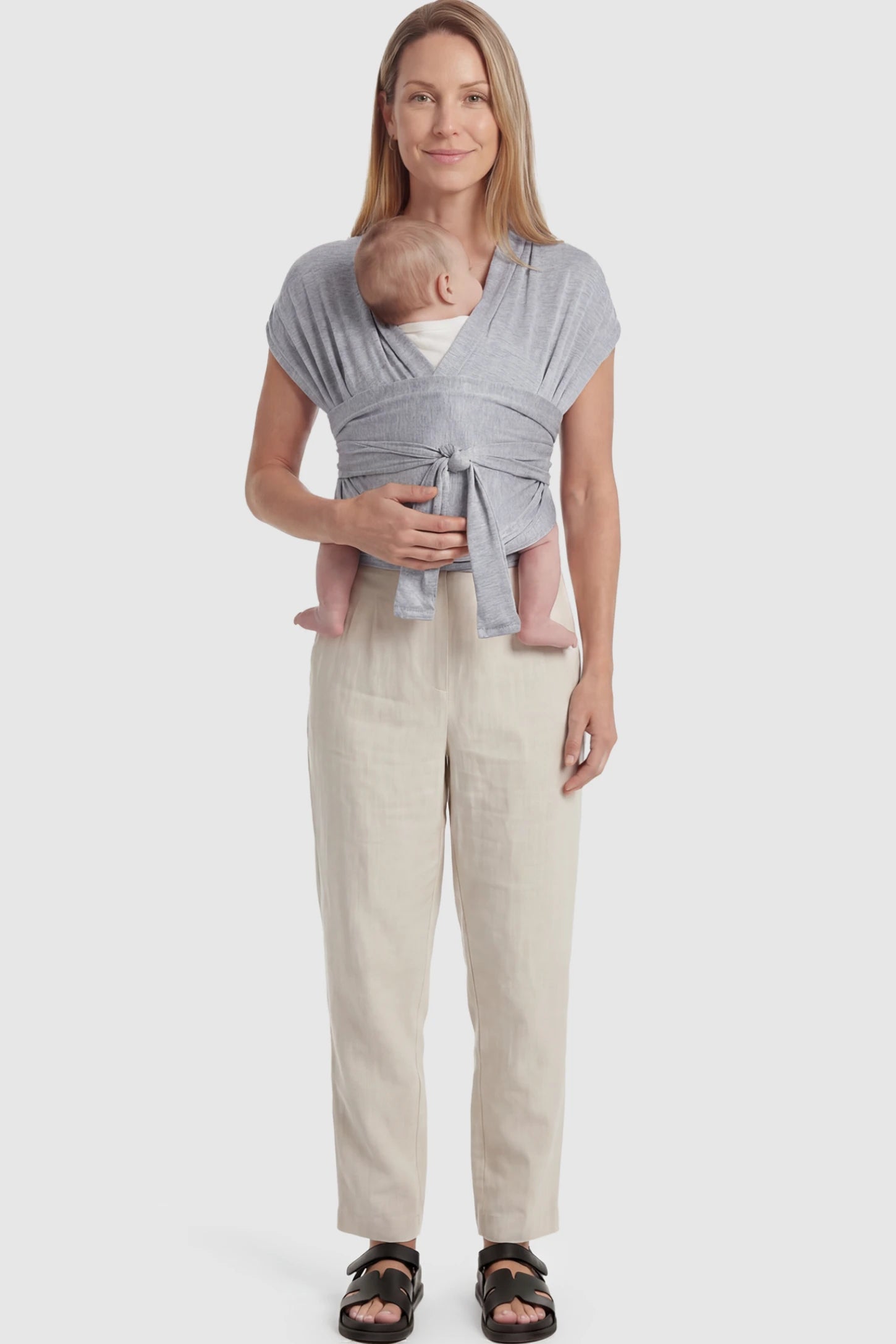Soft Stretch Skin Friendly Baby Wrap Carrier Soft Stretch Skin Friendly Baby Wrap Carrier in Light Gray featuring a secure front-tie knot on a mother holding her newborn showing full body.