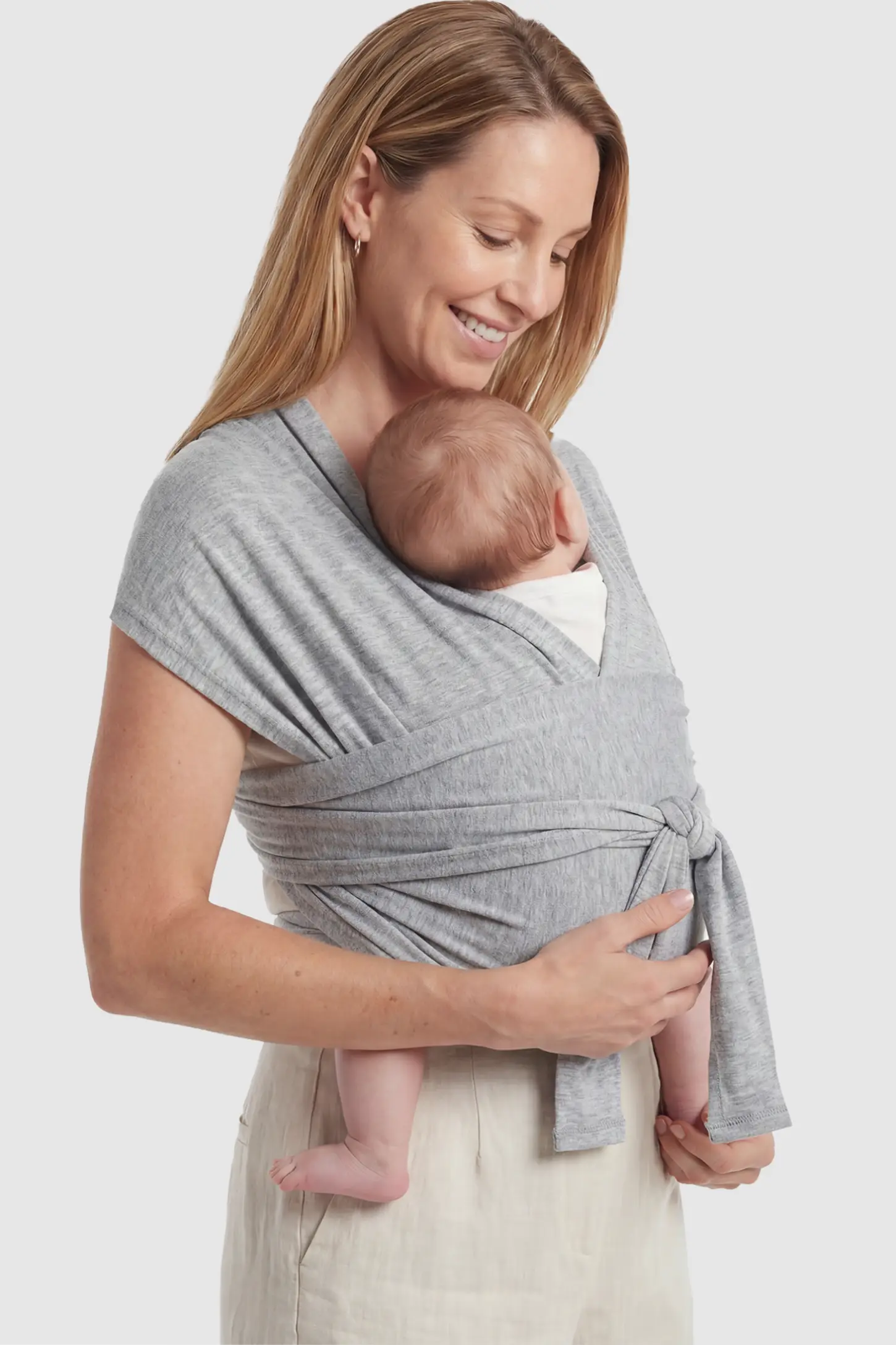 Soft Stretch Skin Friendly Baby Wrap Carrier in Light Gray featuring a secure front-tie knot on a mother holding her newborn showing side.