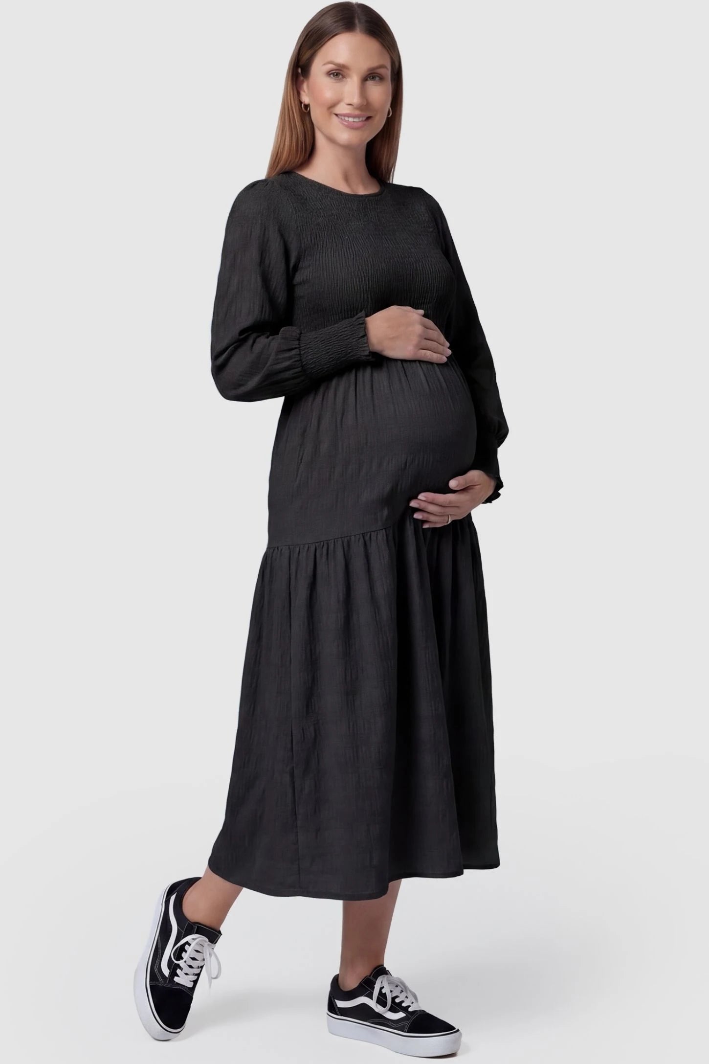 Solid Color Tiered Style Midi Maternity Dress in black featuring a smocked bodice on a pregnant model, front view.