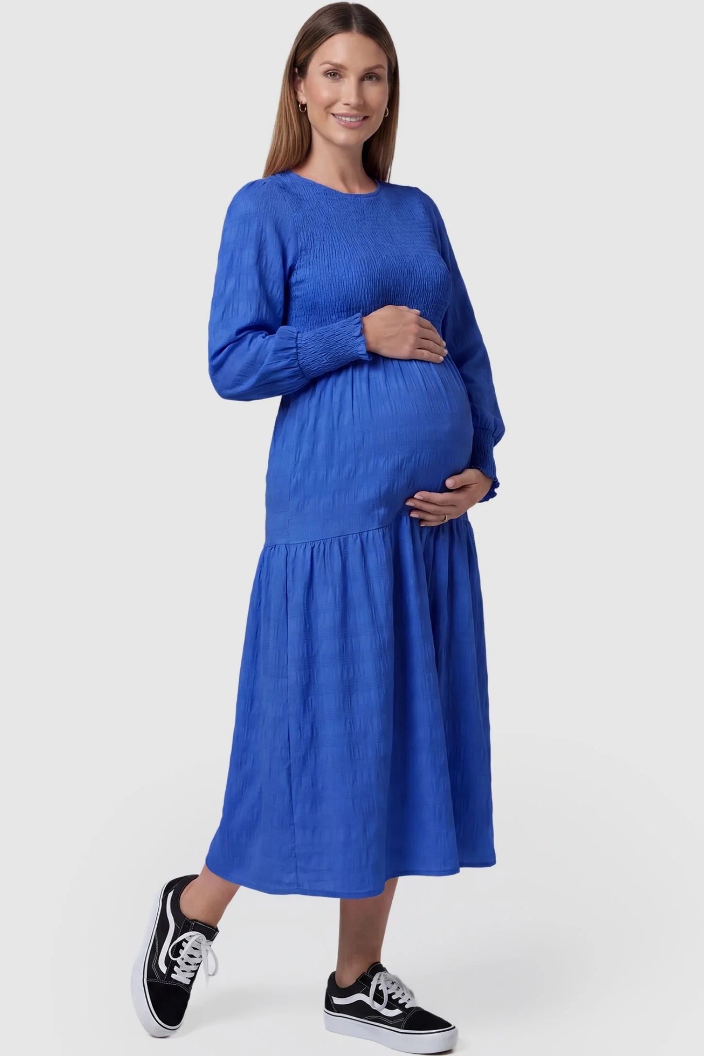 Solid Color Tiered Style Midi Maternity Dress Solid Color Tiered Style Midi Maternity Dress in blue featuring a smocked bodice on a pregnant model, front view.
