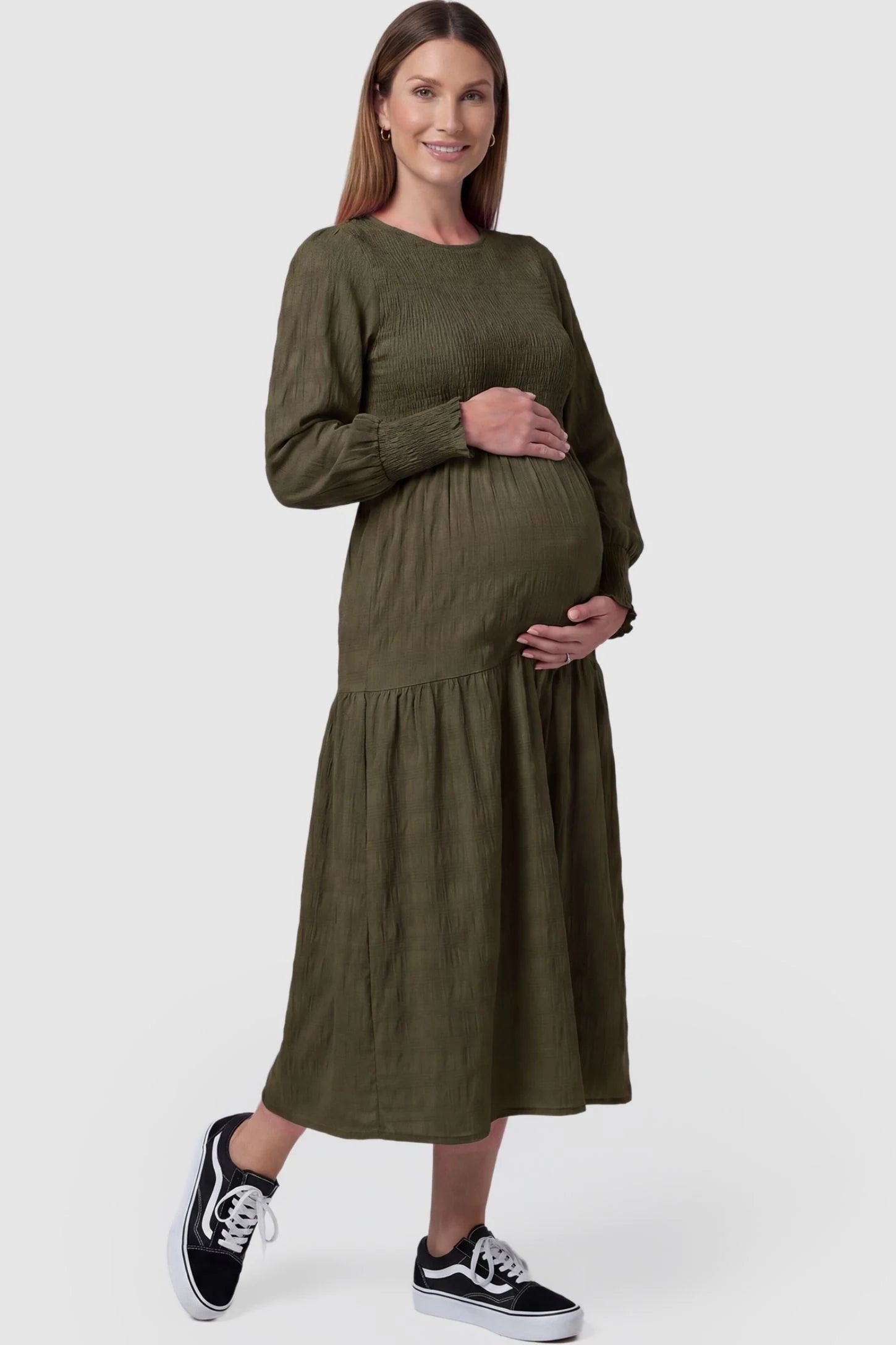Solid Color Tiered Style Midi Maternity Dress Solid Color Tiered Style Midi Maternity Dress in green featuring a smocked bodice on a pregnant model, front view.