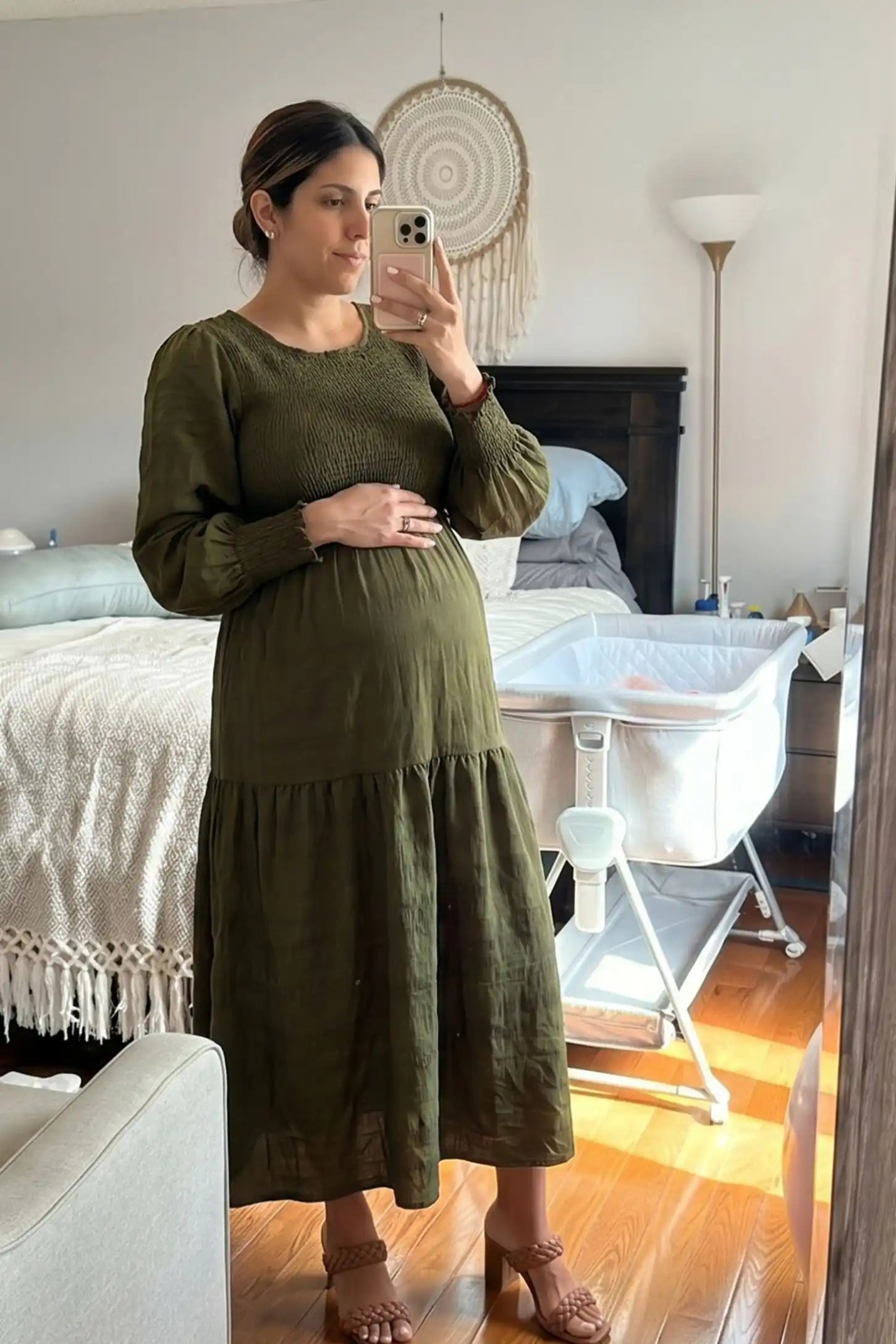 Solid Color Tiered Style Midi Maternity Dress Solid Color Tiered Style Midi Maternity Dress in green featuring a smocked bodice on a pregnant model, UGC view.