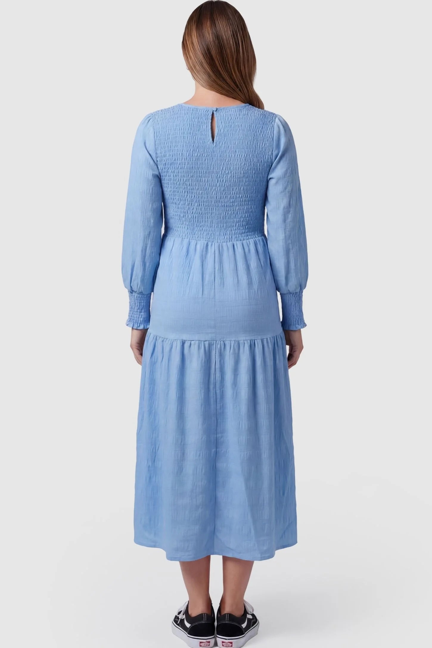 Solid Color Tiered Style Midi Maternity Dress Solid Color Tiered Style Midi Maternity Dress in light blue featuring a smocked bodice on a pregnant model, back view.