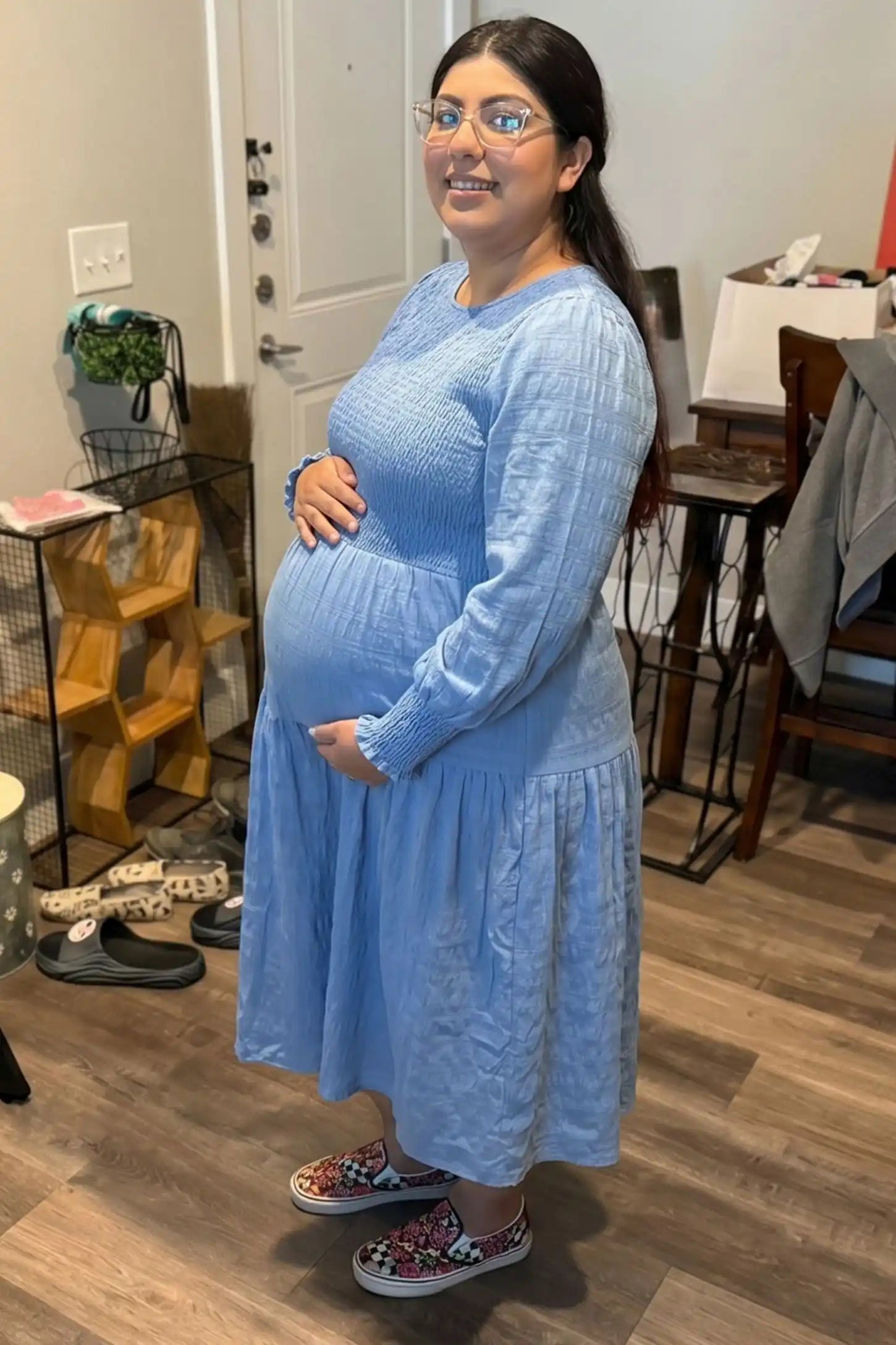 Solid Color Tiered Style Midi Maternity Dress Solid Color Tiered Style Midi Maternity Dress in light blue featuring a smocked bodice on a pregnant model, UGC view.