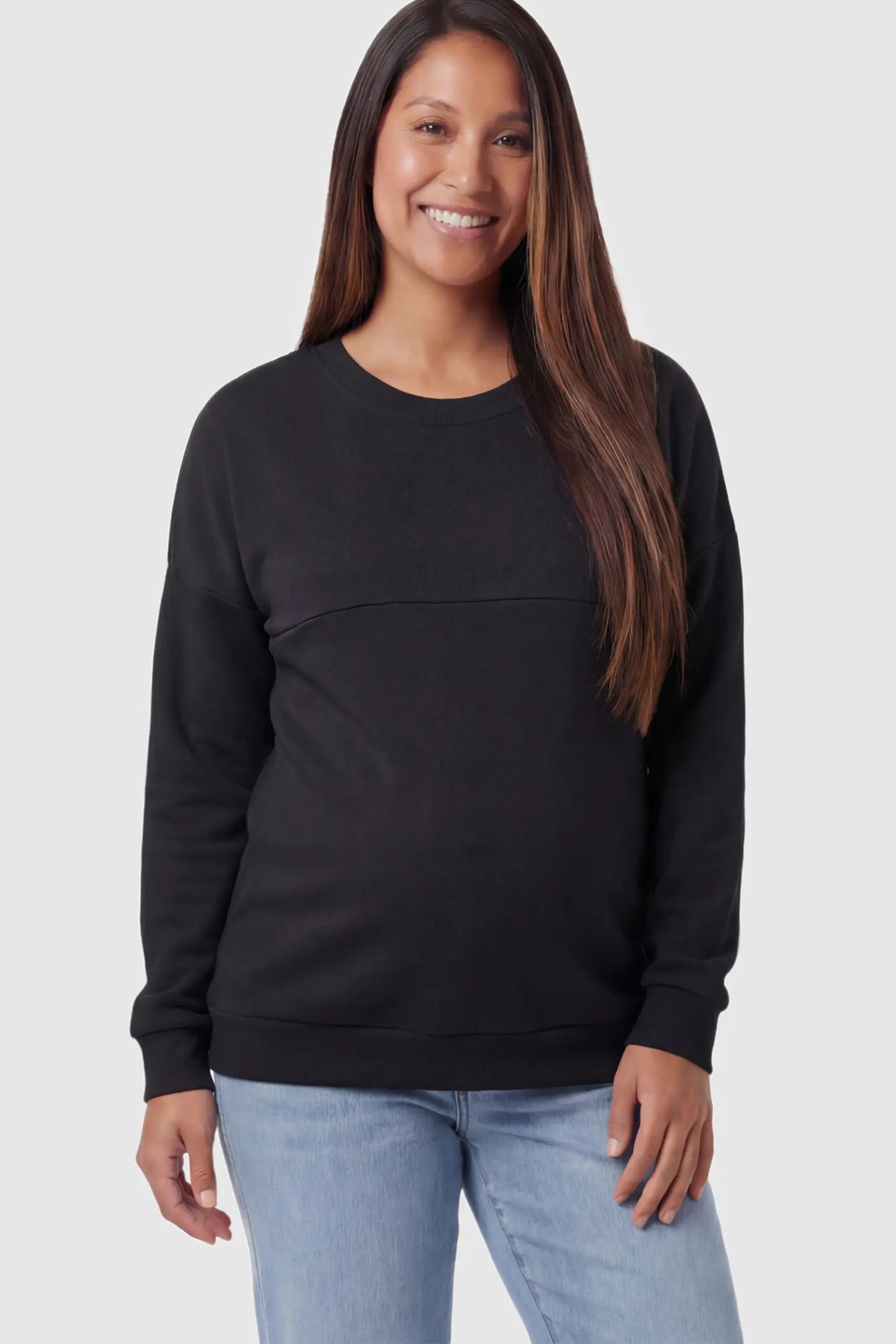 Solid Long Sleeve Maternity & Nursing Sweatshirt in Black featuring a hidden zip raised seam on a pregnant model posing front.