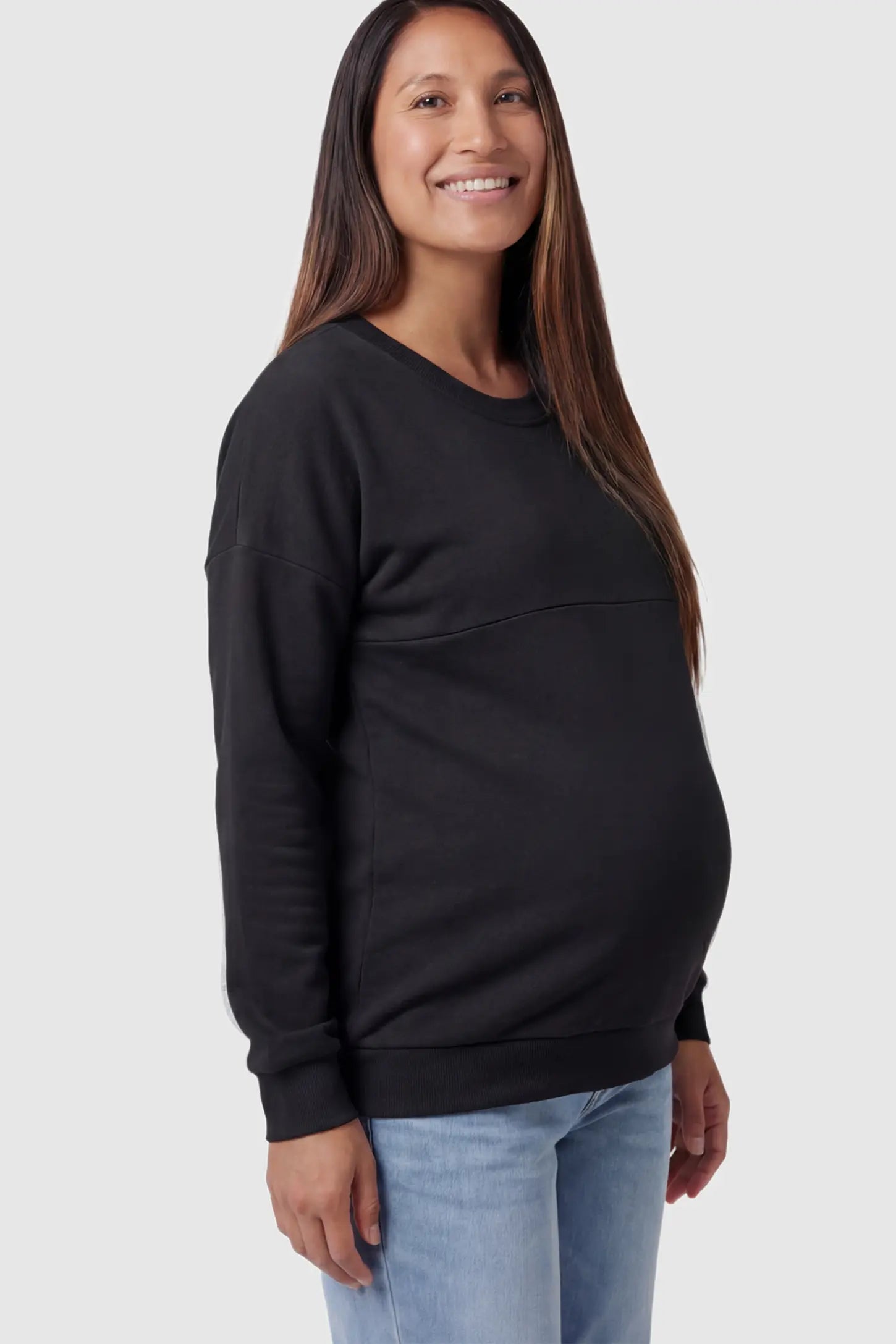 Solid Long Sleeve Maternity & Nursing Sweatshirt in Black featuring a hidden zip raised seam on a pregnant model showing side.