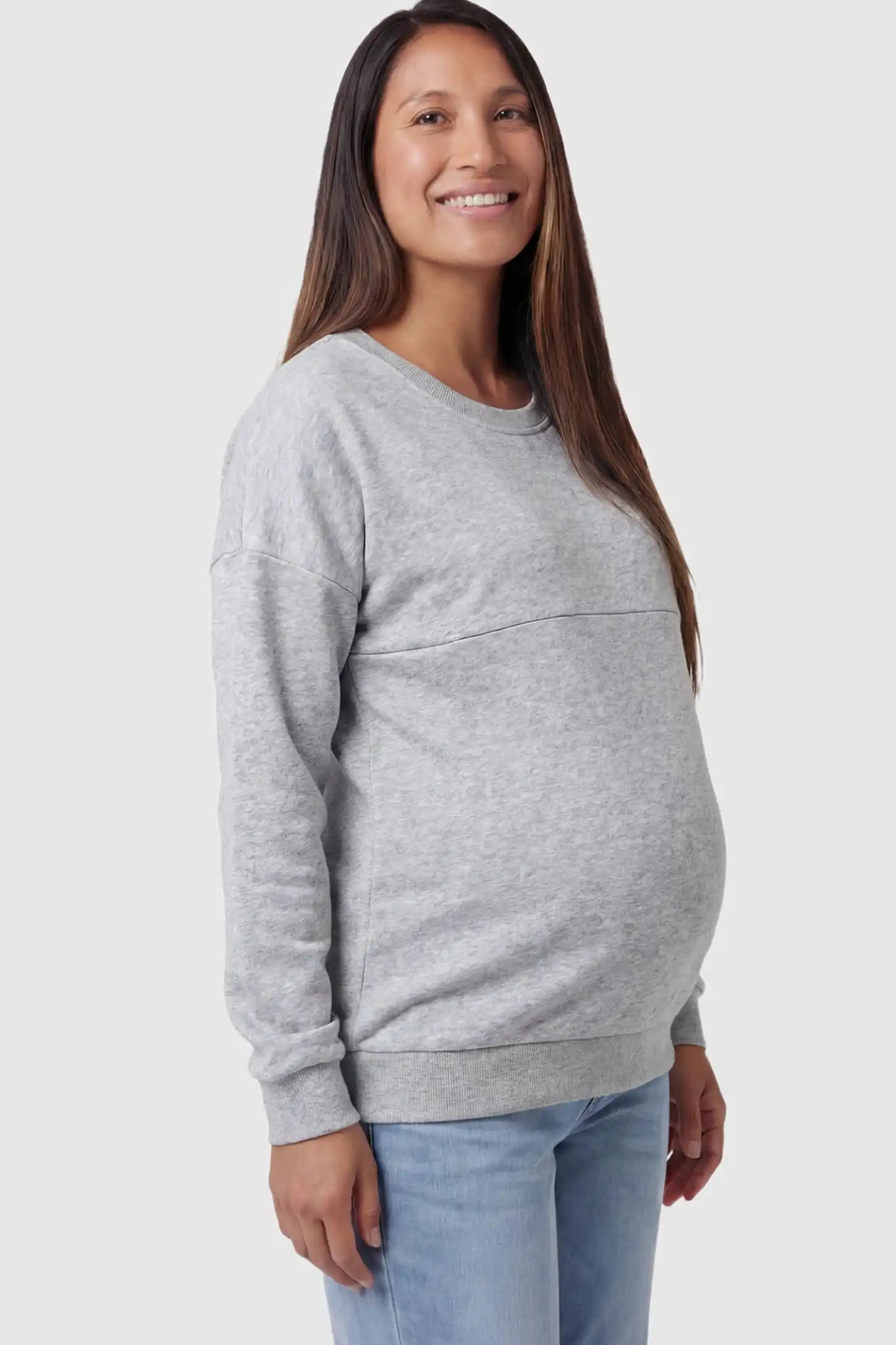 Solid Long Sleeve Maternity & Nursing Sweatshirt Solid Long Sleeve Maternity & Nursing Sweatshirt in Light Gray featuring a hidden zip raised seam on a pregnant model showing side.