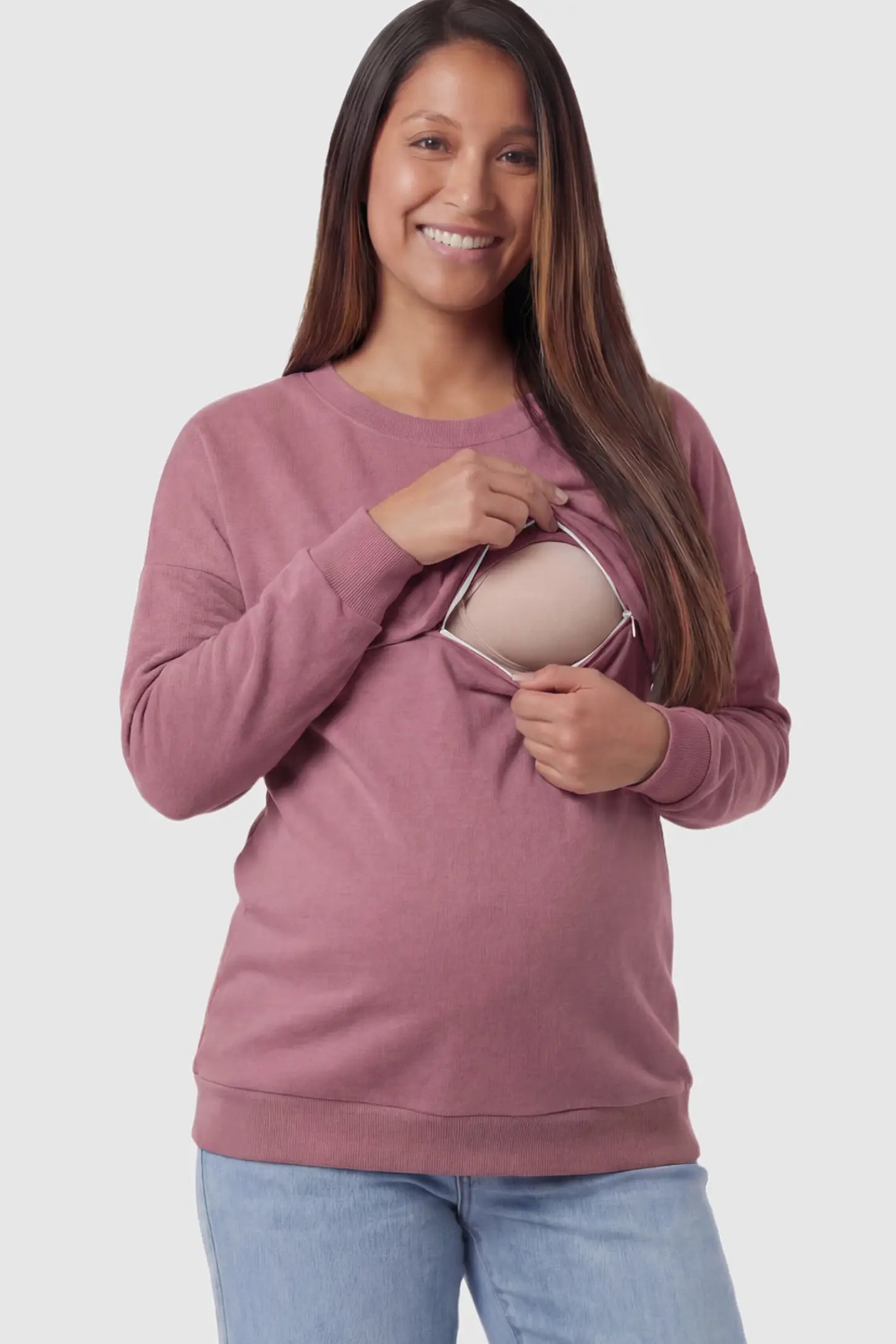 Solid Long Sleeve Maternity & Nursing Sweatshirt Solid Long Sleeve Maternity & Nursing Sweatshirt in Pink featuring a hidden zip raised seam on a pregnant model showing nursing access.