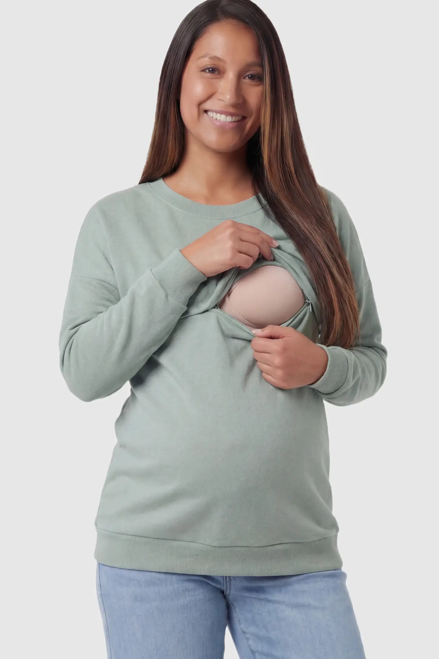 Solid Long Sleeve Maternity & Nursing Sweatshirt Solid Long Sleeve Maternity & Nursing Sweatshirt in Sage Green featuring a hidden zip raised seam on a pregnant model showing nursing access.
