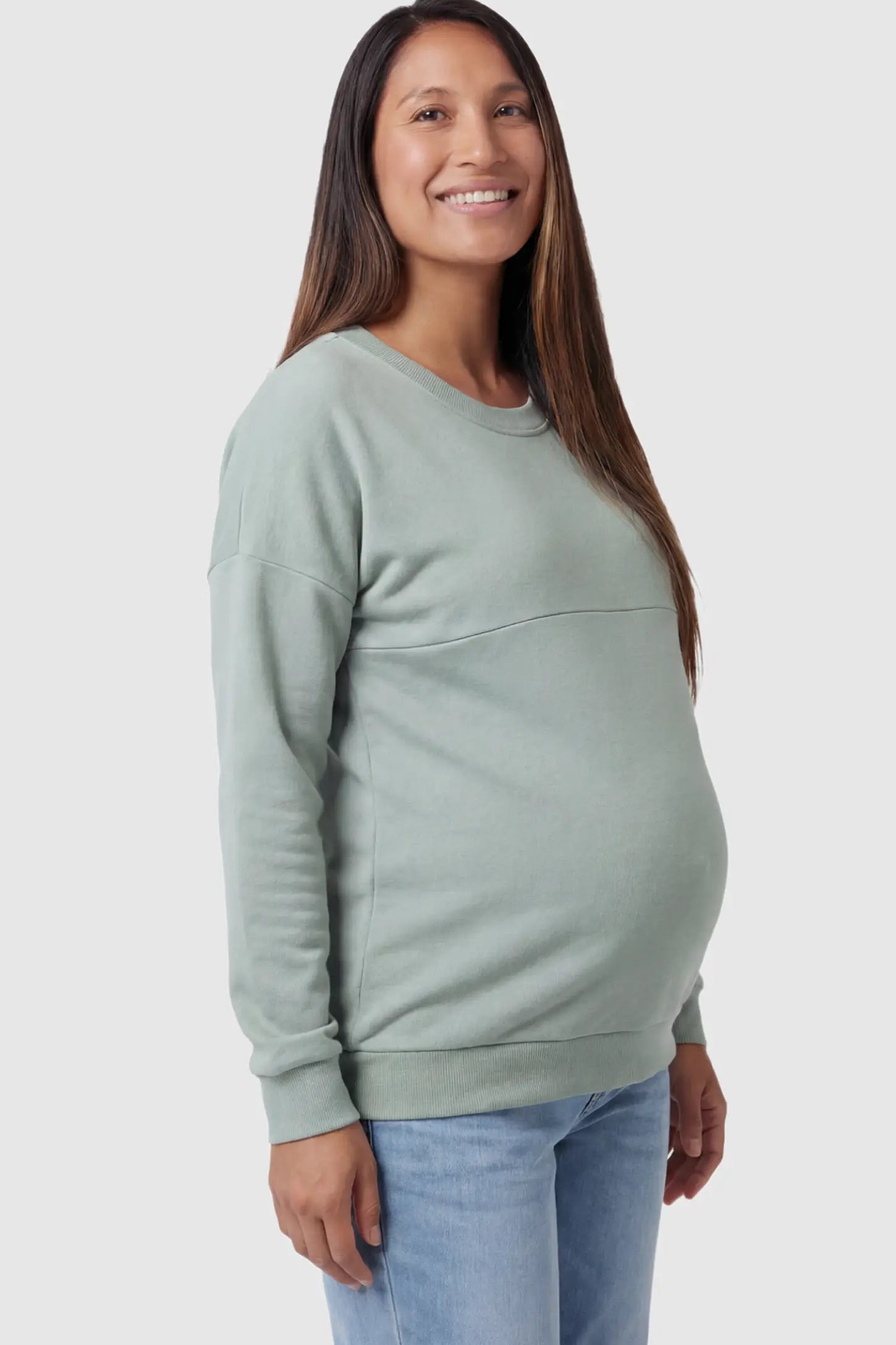 Solid Long Sleeve Maternity & Nursing Sweatshirt Solid Long Sleeve Maternity & Nursing Sweatshirt in Sage Green featuring a hidden zip raised seam on a pregnant model showing side.