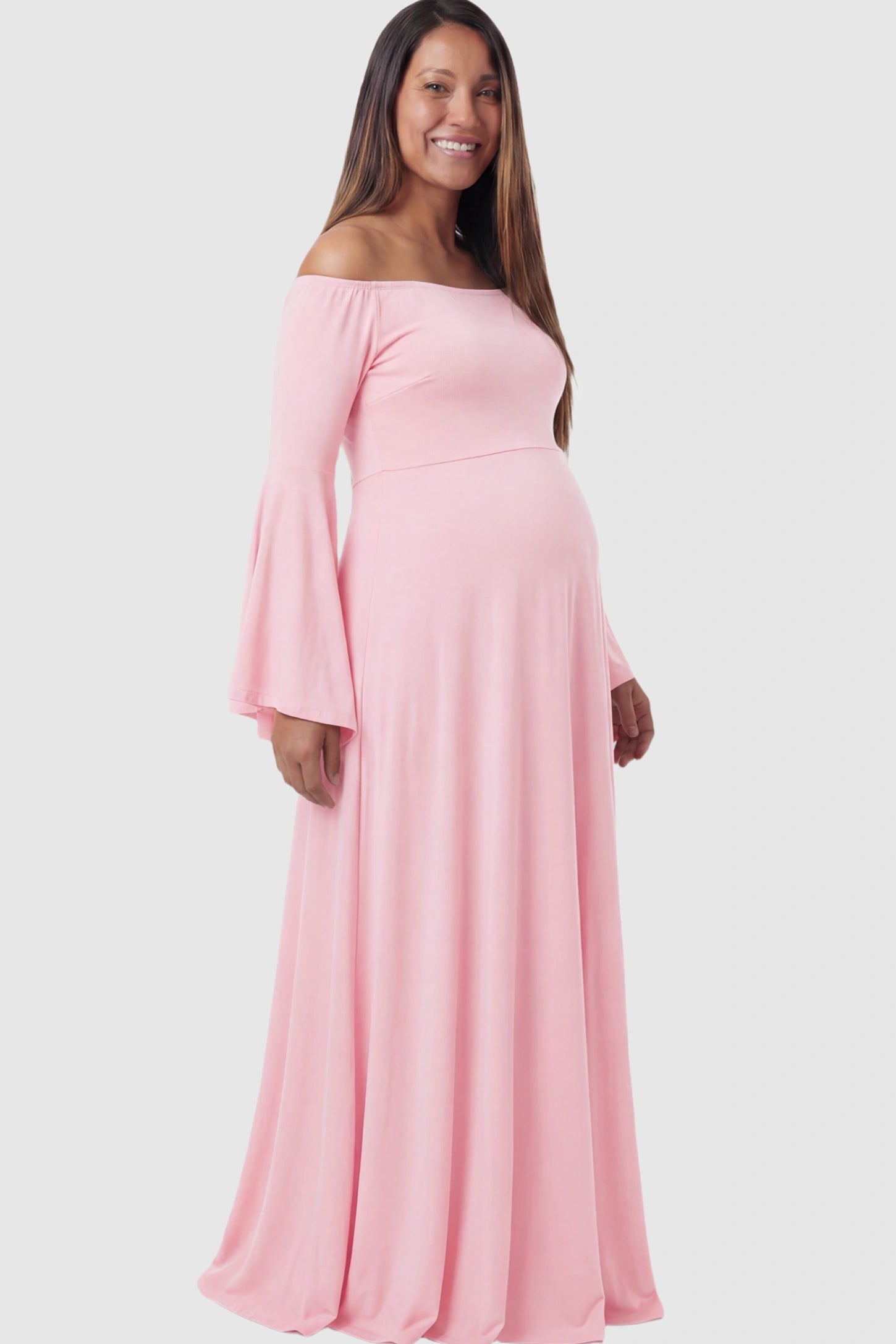 Solid Off Shoulder Bell Sleeve Maternity Maxi Dress Solid Off Shoulder Bell Sleeve Maternity Maxi Dress in Pink featuring Bell sleeves on a pregnant model showing side.