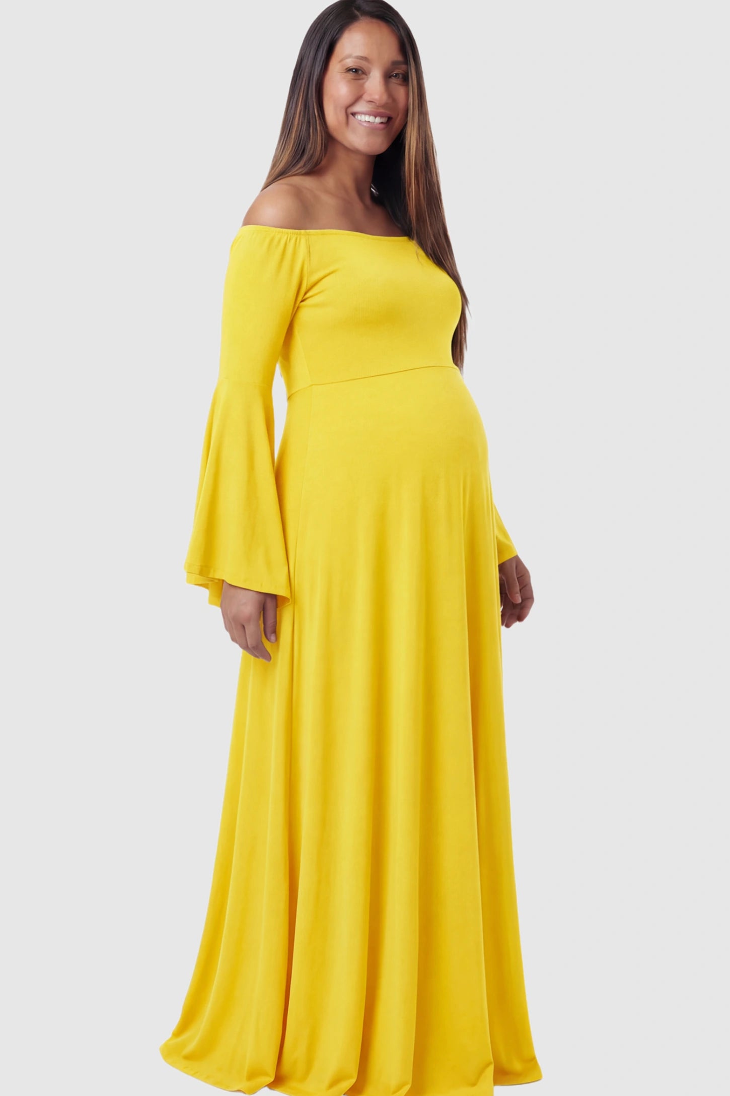 Solid Off Shoulder Bell Sleeve Maternity Maxi Dress Solid Off Shoulder Bell Sleeve Maternity Maxi Dress in Yellow featuring Bell sleeves on a pregnant model showing side.