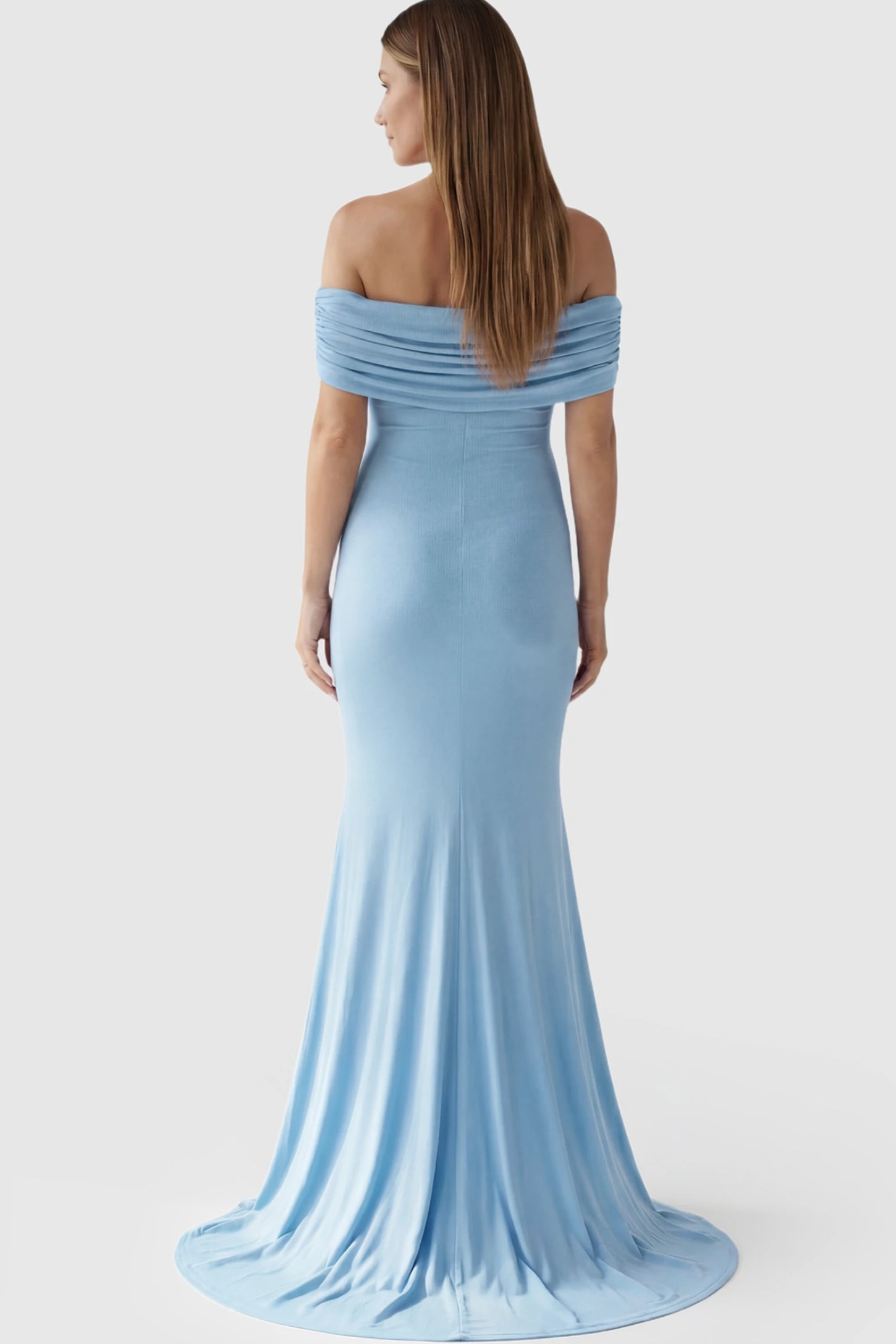 Solid Off Shoulder Maternity Photoshoot Gown Solid Off-Shoulder Maternity Photoshoot Gown in light blue featuring subtle train on a pregnant model showing back.