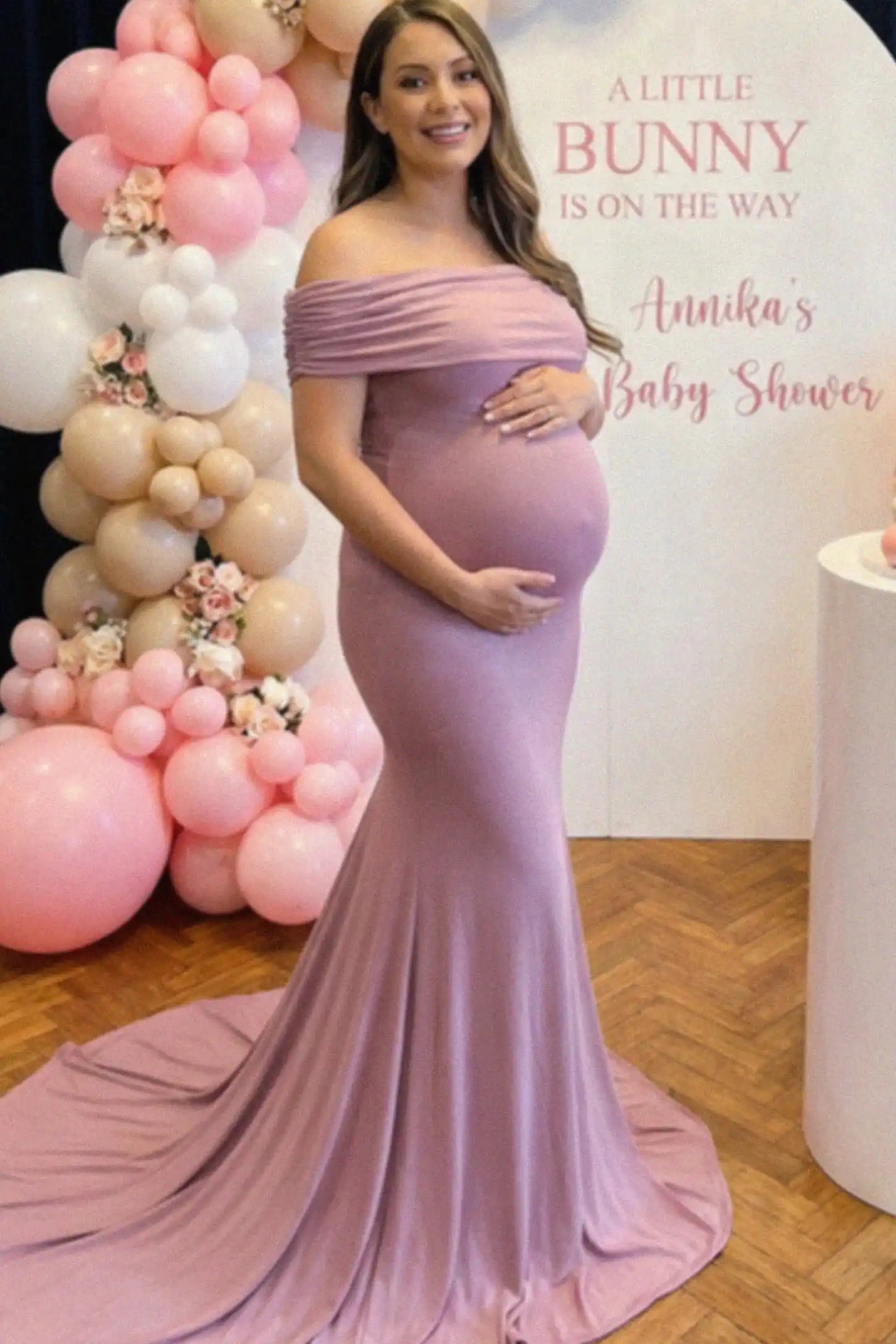 Solid Off Shoulder Maternity Photoshoot Gown Solid Off-Shoulder Maternity Photoshoot Gown in Pink featuring subtle train on a pregnant woman showing front.