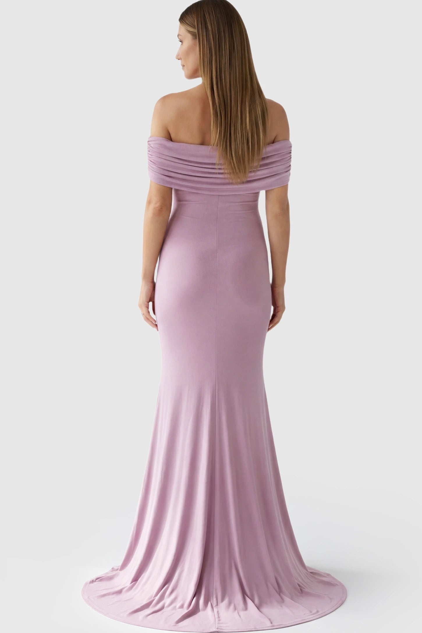 Solid Off Shoulder Maternity Photoshoot Gown Solid Off-Shoulder Maternity Photoshoot Gown in Pink featuring subtle train on a pregnant model showing back.
