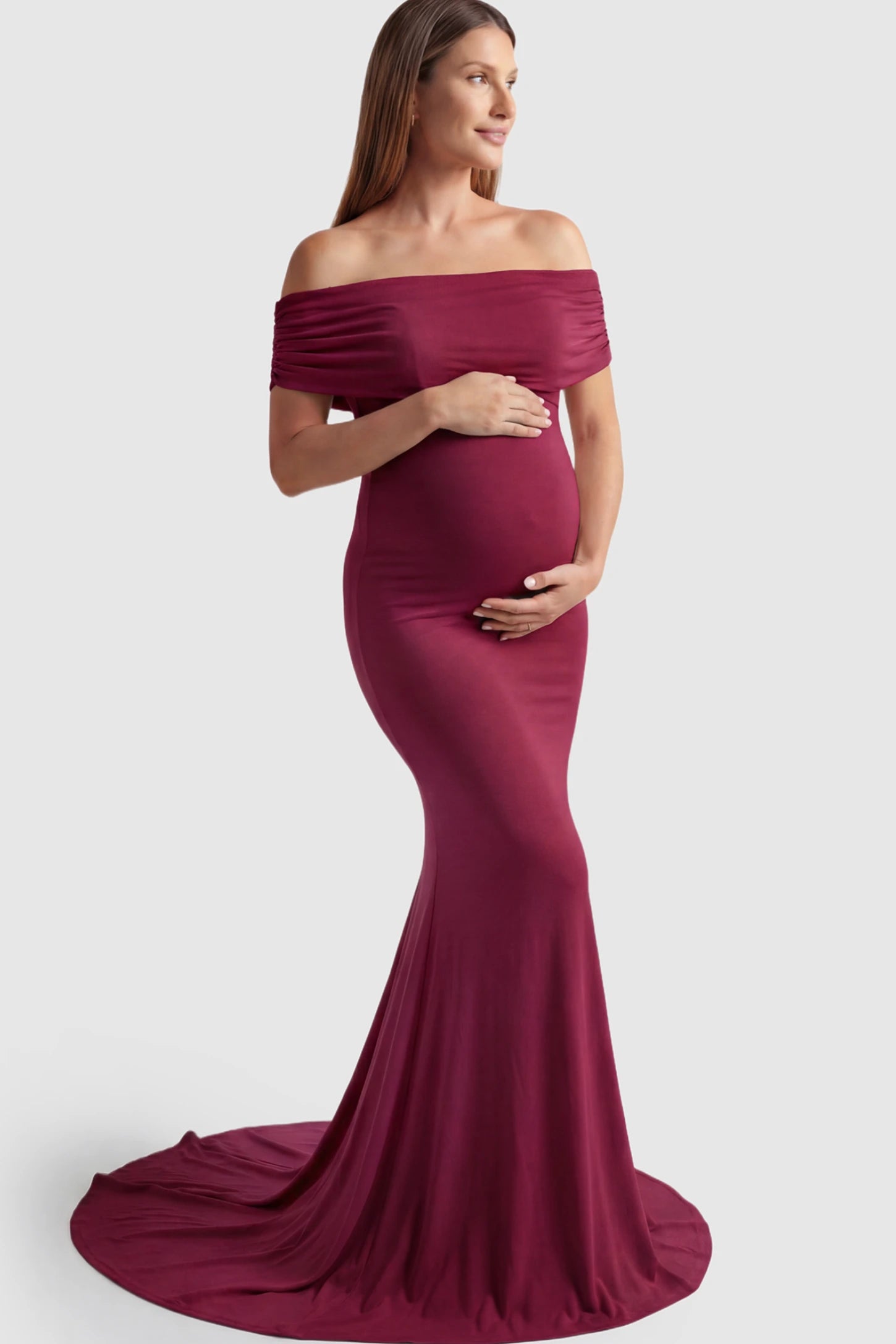 Solid Off Shoulder Maternity Photoshoot Gown Solid Off-Shoulder Maternity Photoshoot Gown in red featuring subtle train on a pregnant model showing front.