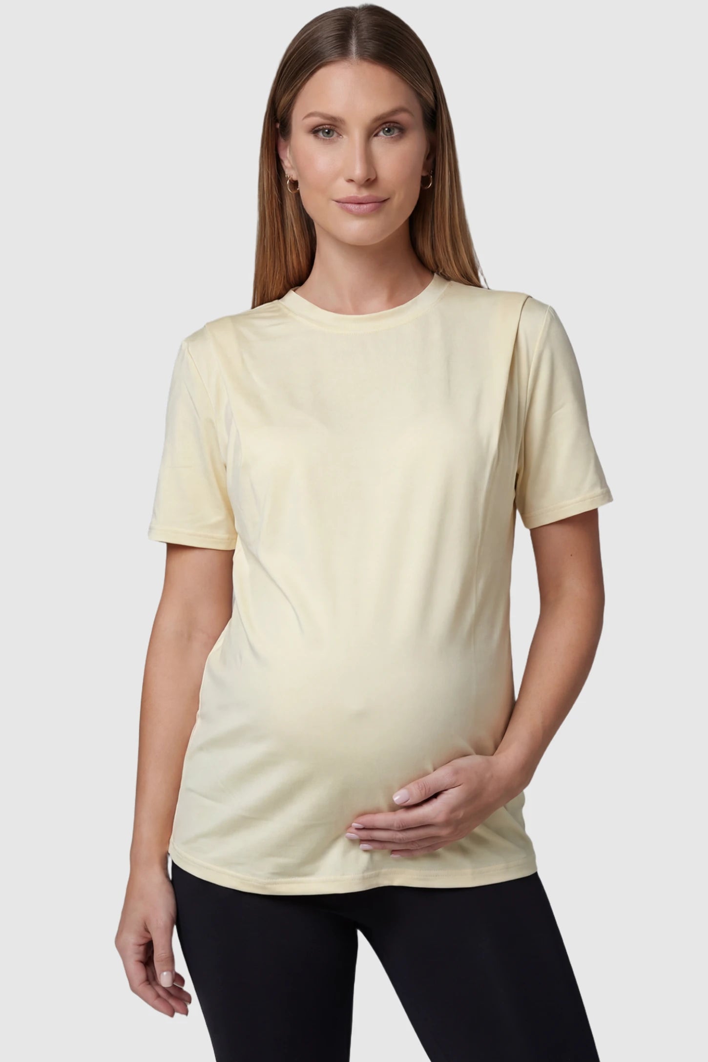 Solid Round Neck Short Sleeve Maternity Top in Beige featuring a soft-touch finish and relaxed fit on a pregnant model, front view.