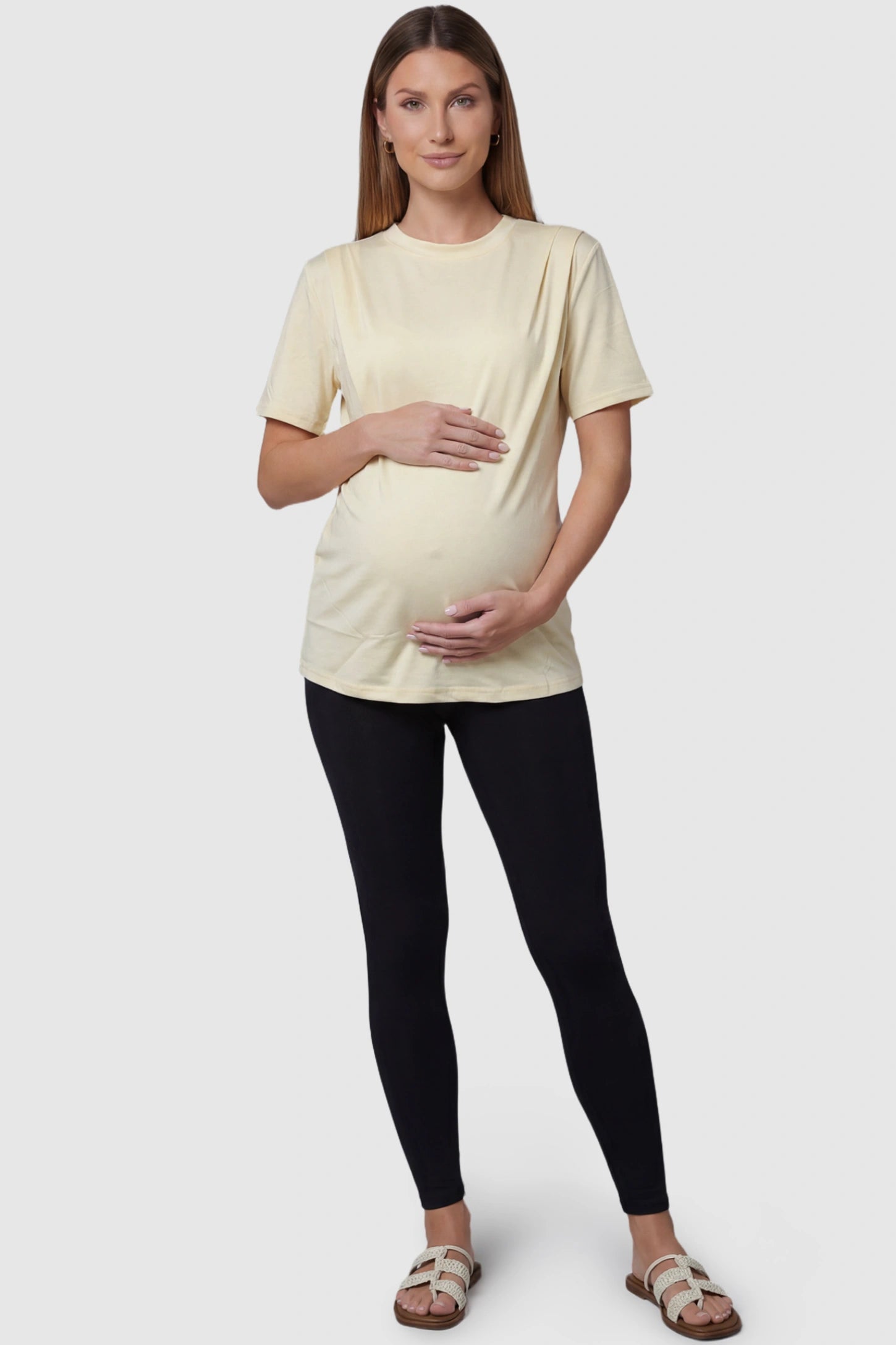 Solid Round Neck Short Sleeve Maternity Top Solid Round Neck Short Sleeve Maternity Top in Beige featuring a soft-touch finish and relaxed fit on a pregnant model, full body view.