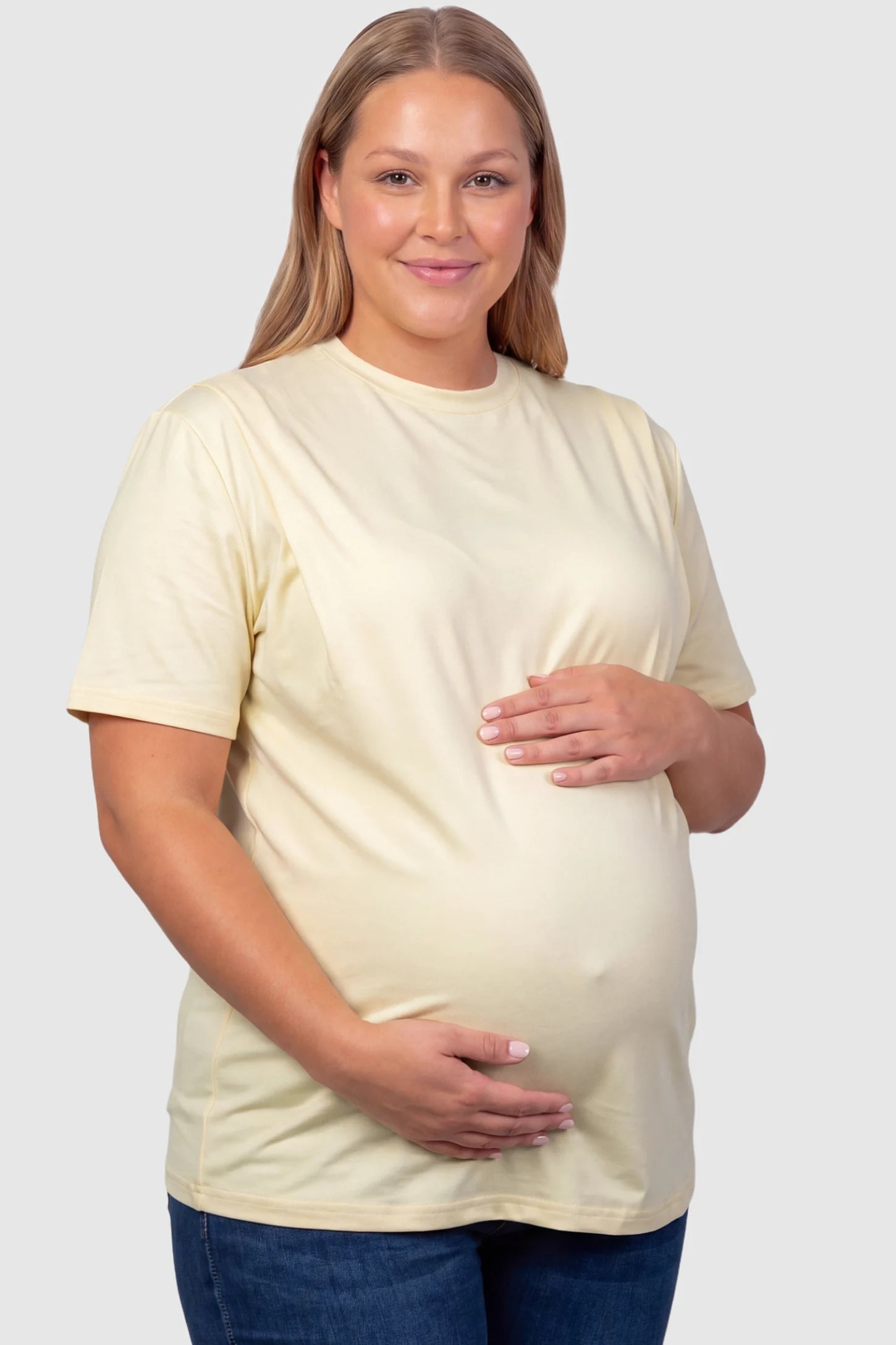 Solid Round Neck Short Sleeve Maternity Top Solid Round Neck Short Sleeve Maternity Top in Beige featuring a soft-touch finish and relaxed fit on a plus size pregnant model, front view.