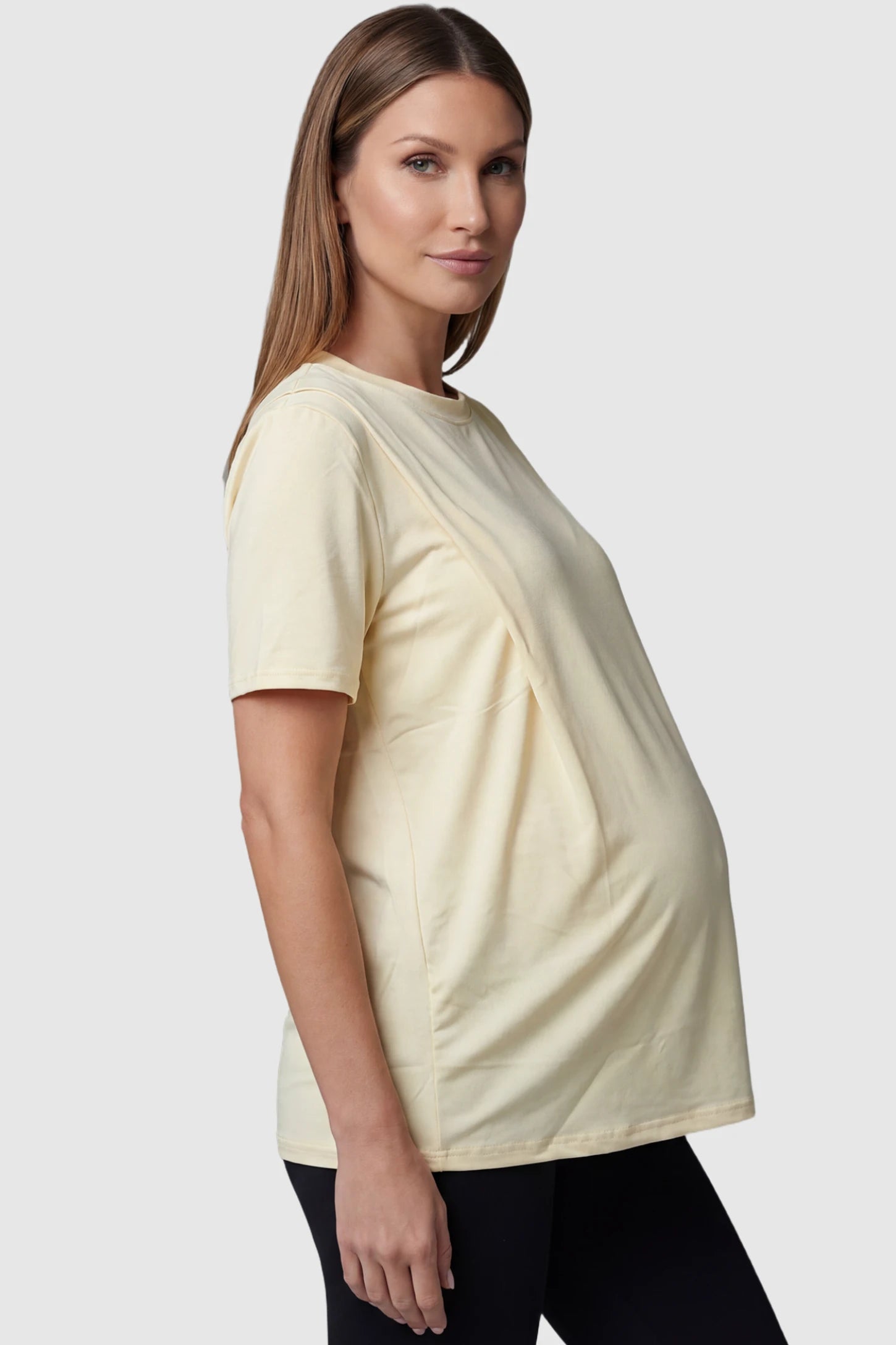 Solid Round Neck Short Sleeve Maternity Top in Beige featuring a soft-touch finish and relaxed fit on a pregnant model, side view.