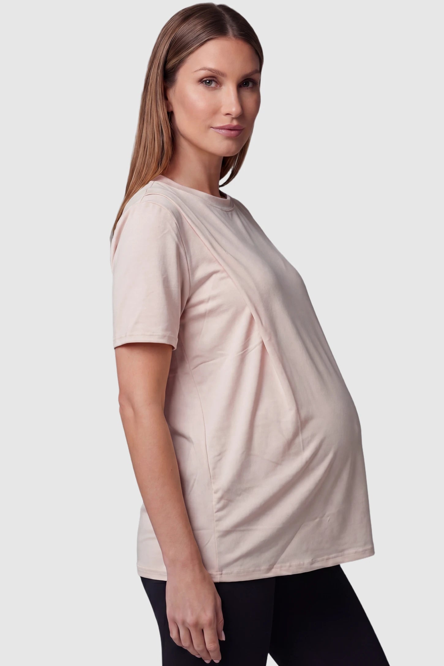 Solid Round Neck Short Sleeve Maternity Top Solid Round Neck Short Sleeve Maternity Top in Brown featuring a soft-touch finish and relaxed fit on a pregnant model, side view.