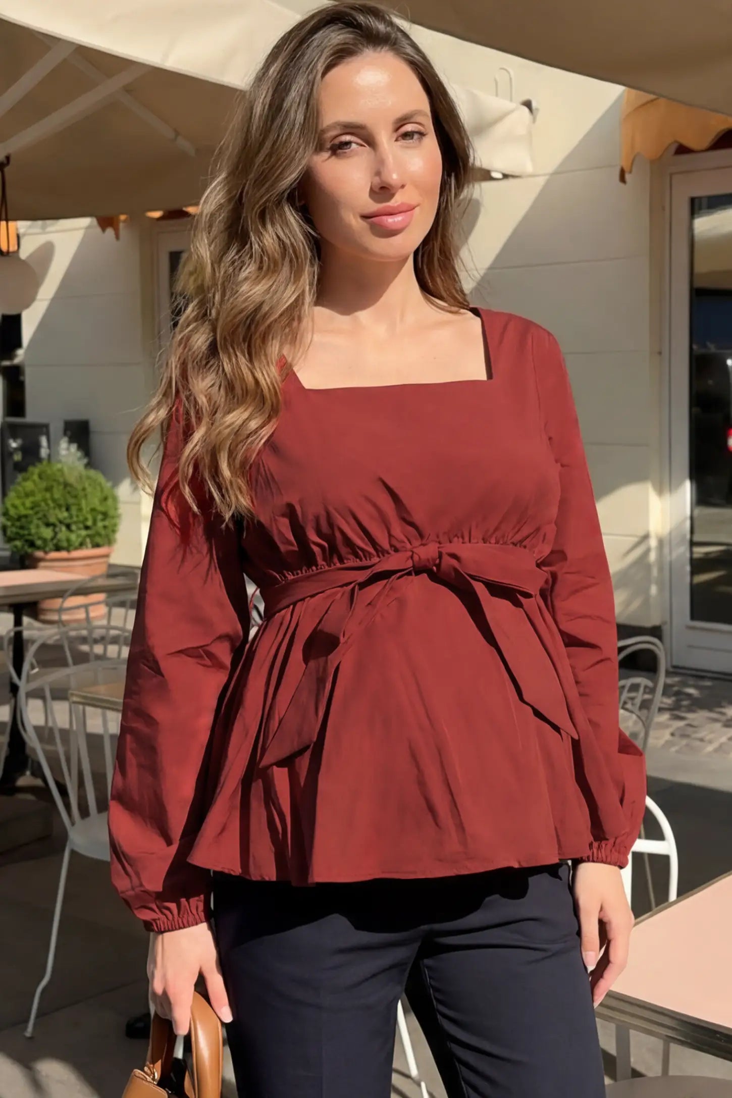 Solid Square Neck Empire Waist Maternity Top Solid Square Neck Empire Waist Maternity Top in Burgundy featuring square neck on a pregnant model in an outdoor brunch setting front view.