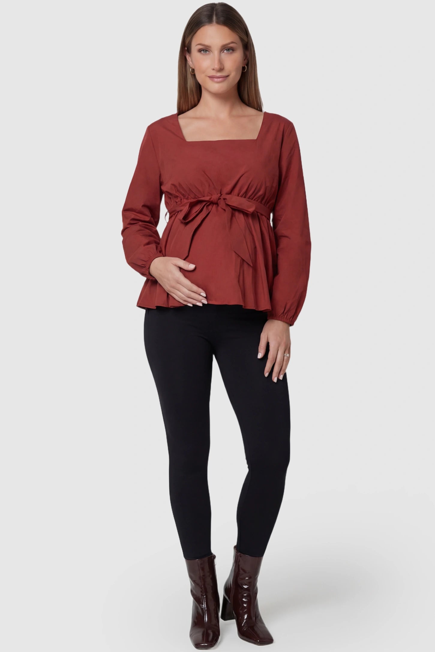 Solid Square Neck Empire Waist Maternity Top Solid Square Neck Empire Waist Maternity Top in Burgundy featuring a lightweight peplum silhouette on a pregnant model full body view.