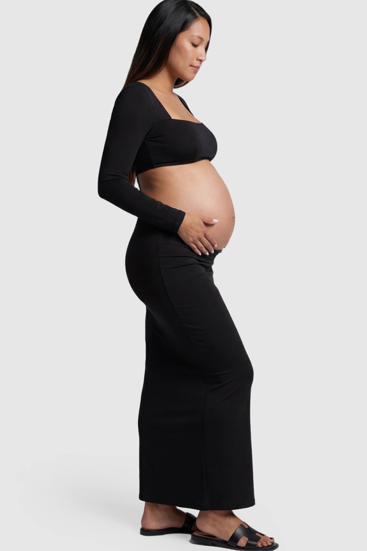 Solid Square Neck Long Sleeve Bodycon Maternity Maxi Dress Solid Square Neck Long Sleeve Bodycon Maternity Maxi Dress in Black featuring a bodycon fit on a pregnant model showing side.