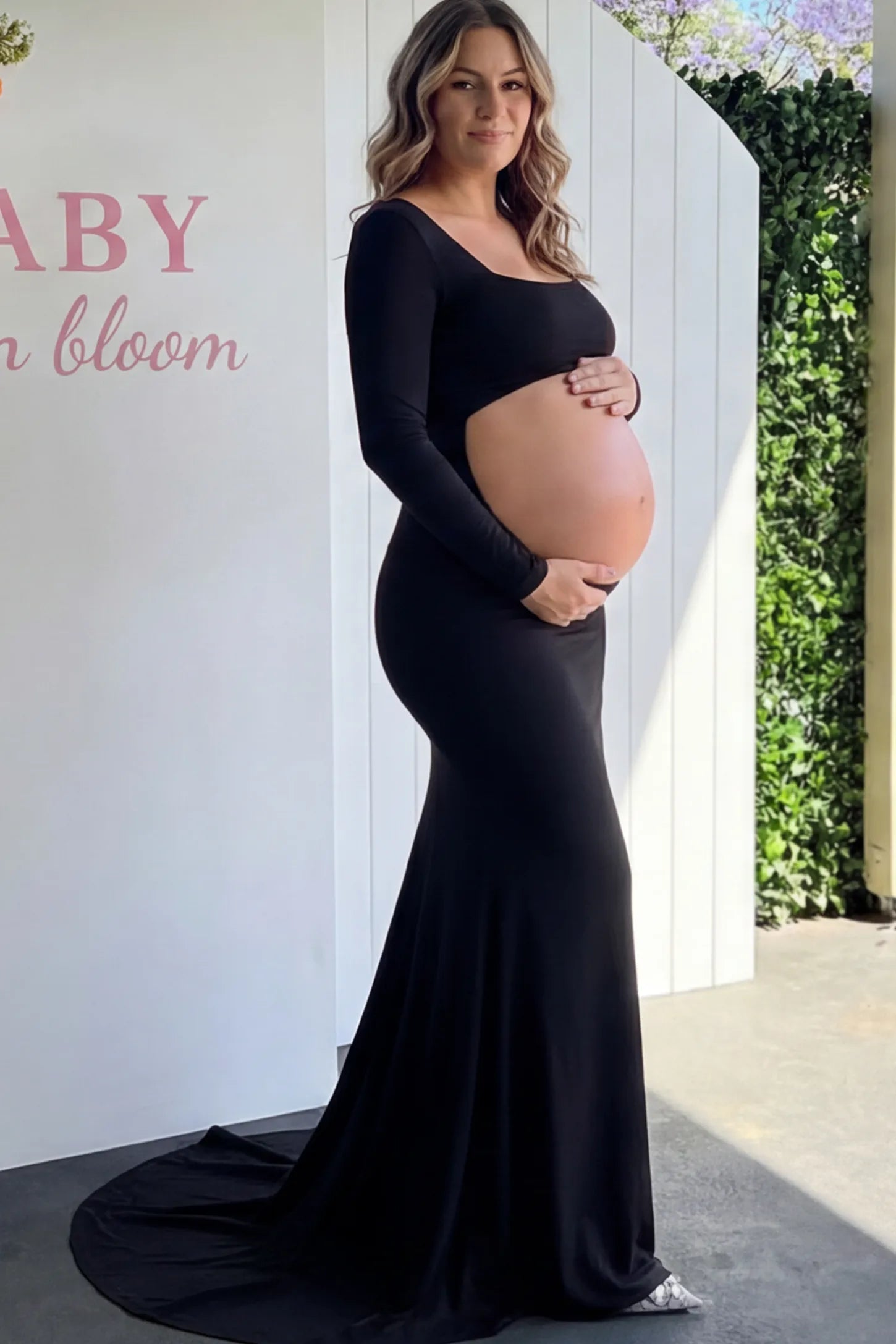 Solid Square Neck Long Sleeve Maternity Maxi Dress in black featuring a bold belly cut-out on a pregnant model showing side.