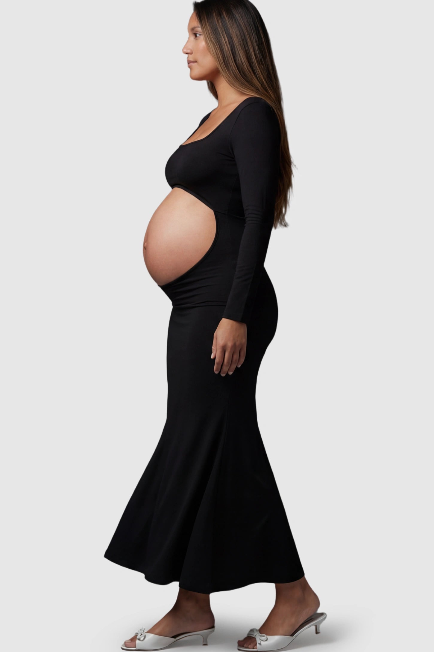 Solid Square Neck Long Sleeve Maternity Maxi Dress Solid Square Neck Long Sleeve Maternity Maxi Dress in black featuring a bold belly cut-out on a pregnant model showing side.