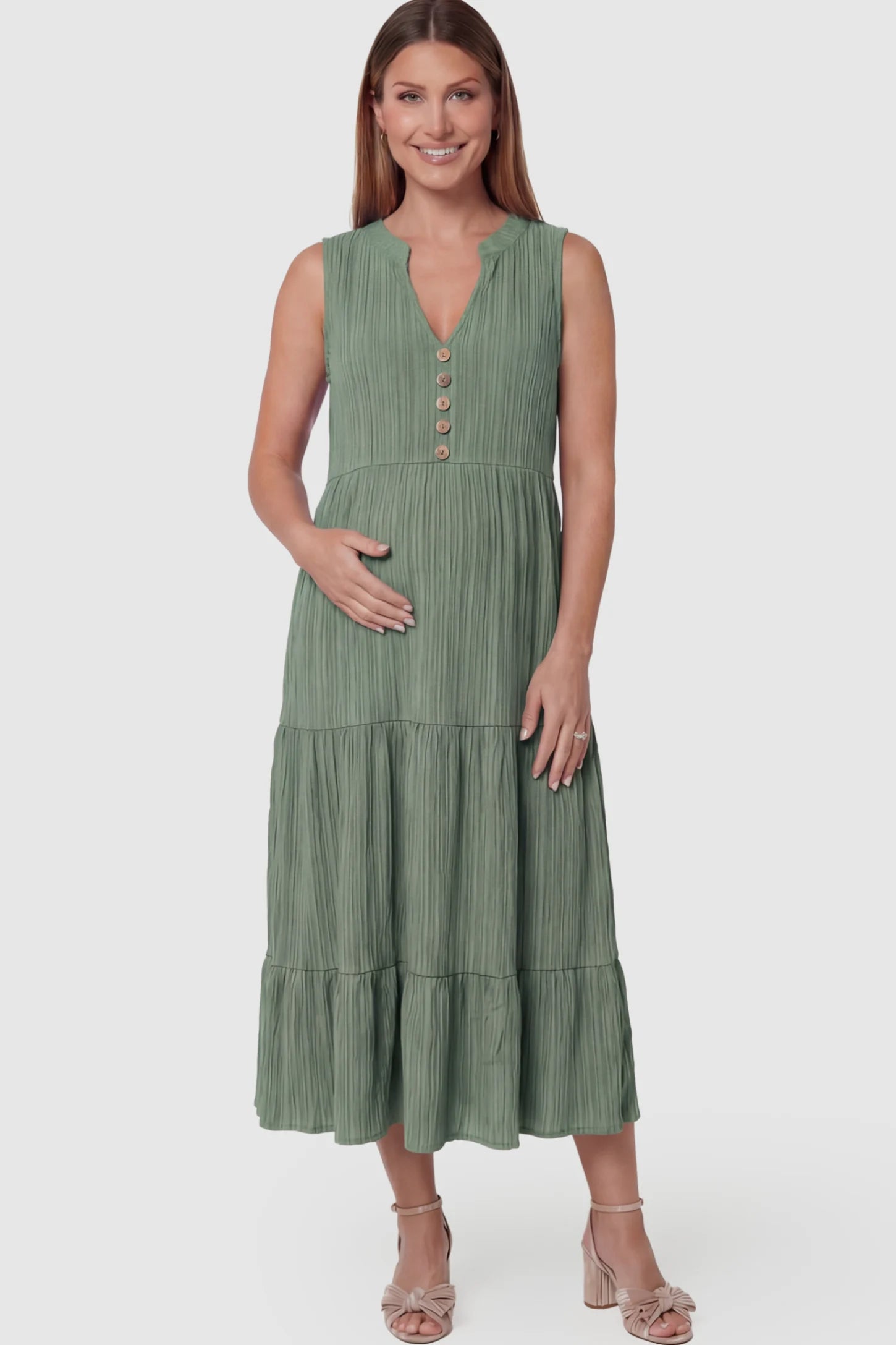 Solid Textured V-Neck Tiered Maternity Midi Dress Solid Textured V-Neck Tiered Maternity Midi Dress in Green featuring a high-waisted A-line silhouette on a pregnant model posing front.