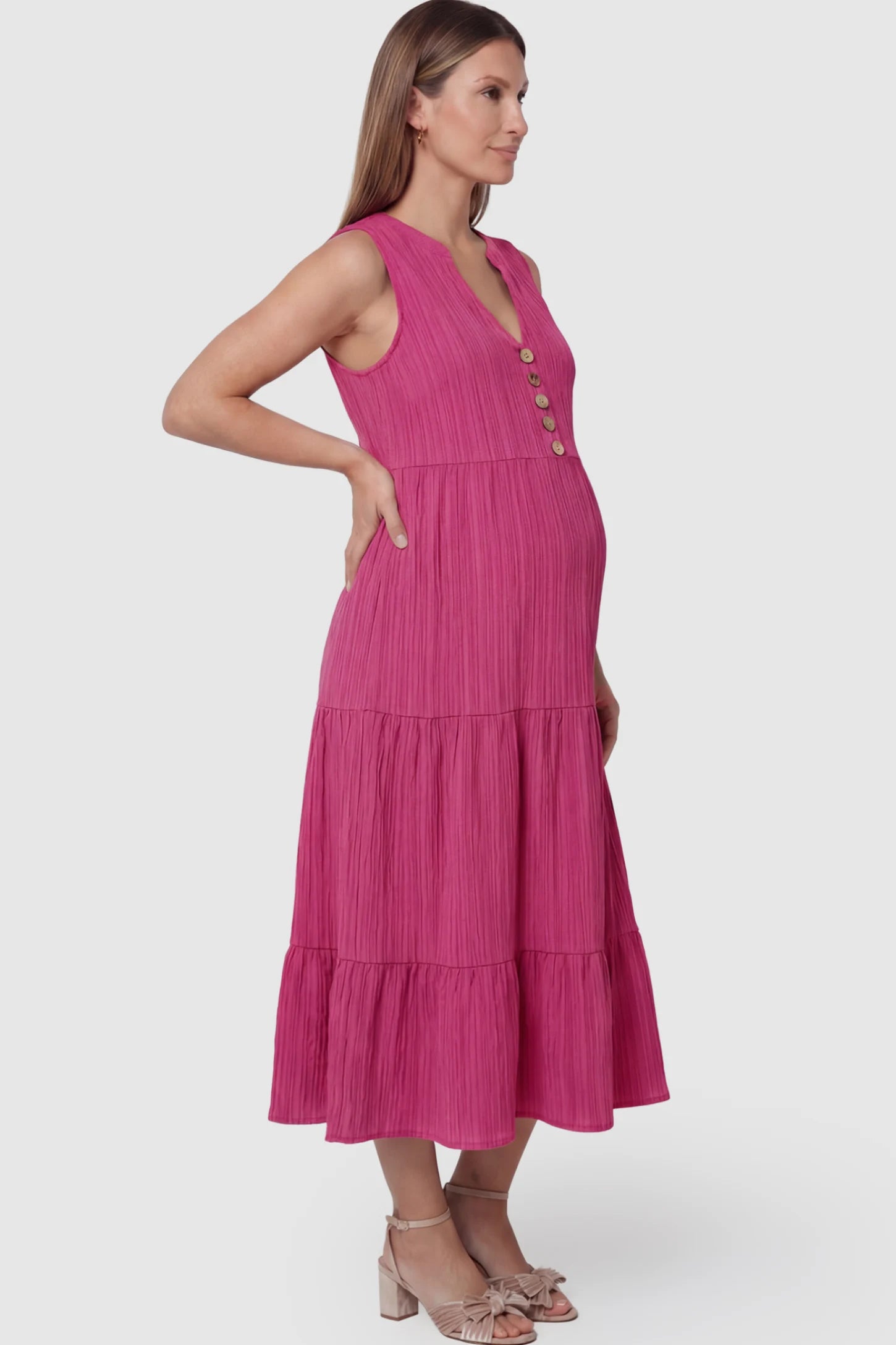 Solid Textured V-Neck Tiered Maternity Midi Dress in Rose Red featuring a high-waisted A-line silhouette on a pregnant model showing side.