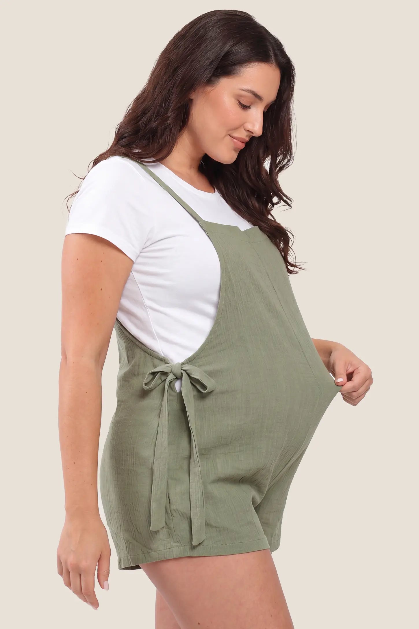 Side view of Green Spaghetti Strap Tie-Side Maternity Romper highlighting the adjustable side-tie closures on a pregnant model.