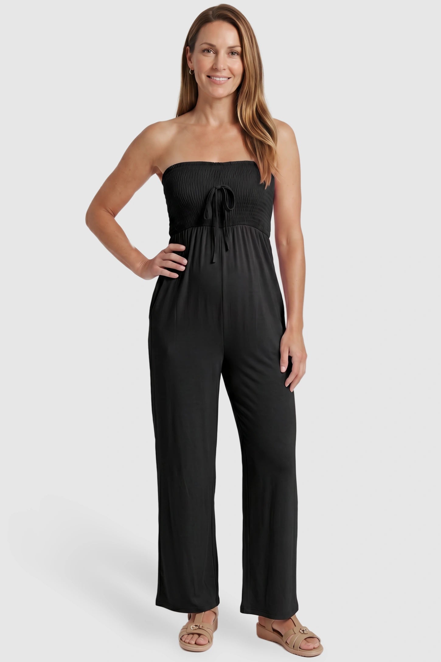Strapless Smocked Bust Wide Leg Maternity Jumpsuit Strapless Smocked Bust Wide Leg Maternity Jumpsuit in Black featuring a relaxed leg design on a postpartum model, front view.