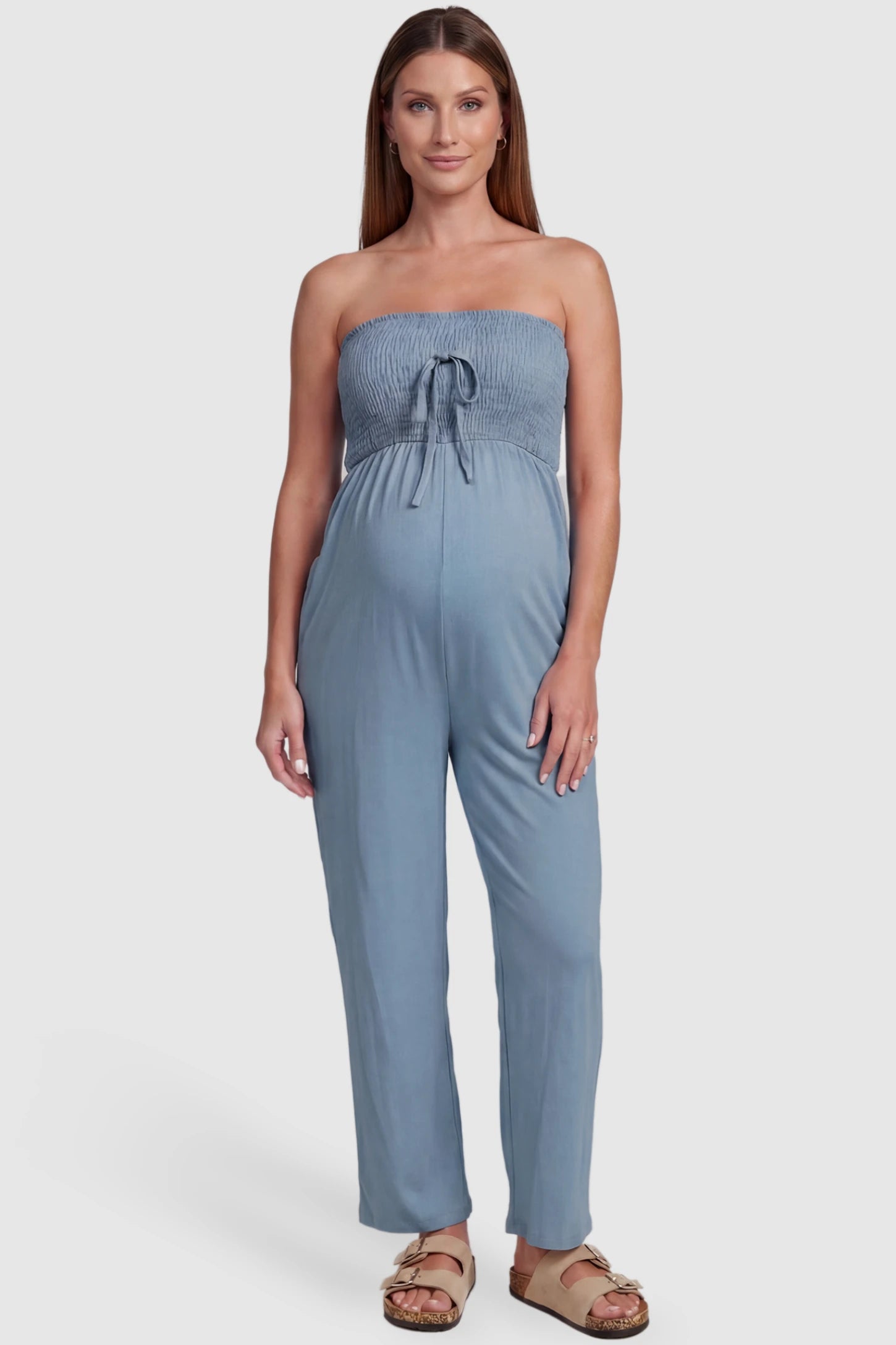 Strapless Smocked Bust Wide Leg Maternity Jumpsuit Strapless Smocked Bust Wide Leg Maternity Jumpsuit in Blue featuring a relaxed leg design on a pregnant model, front view.