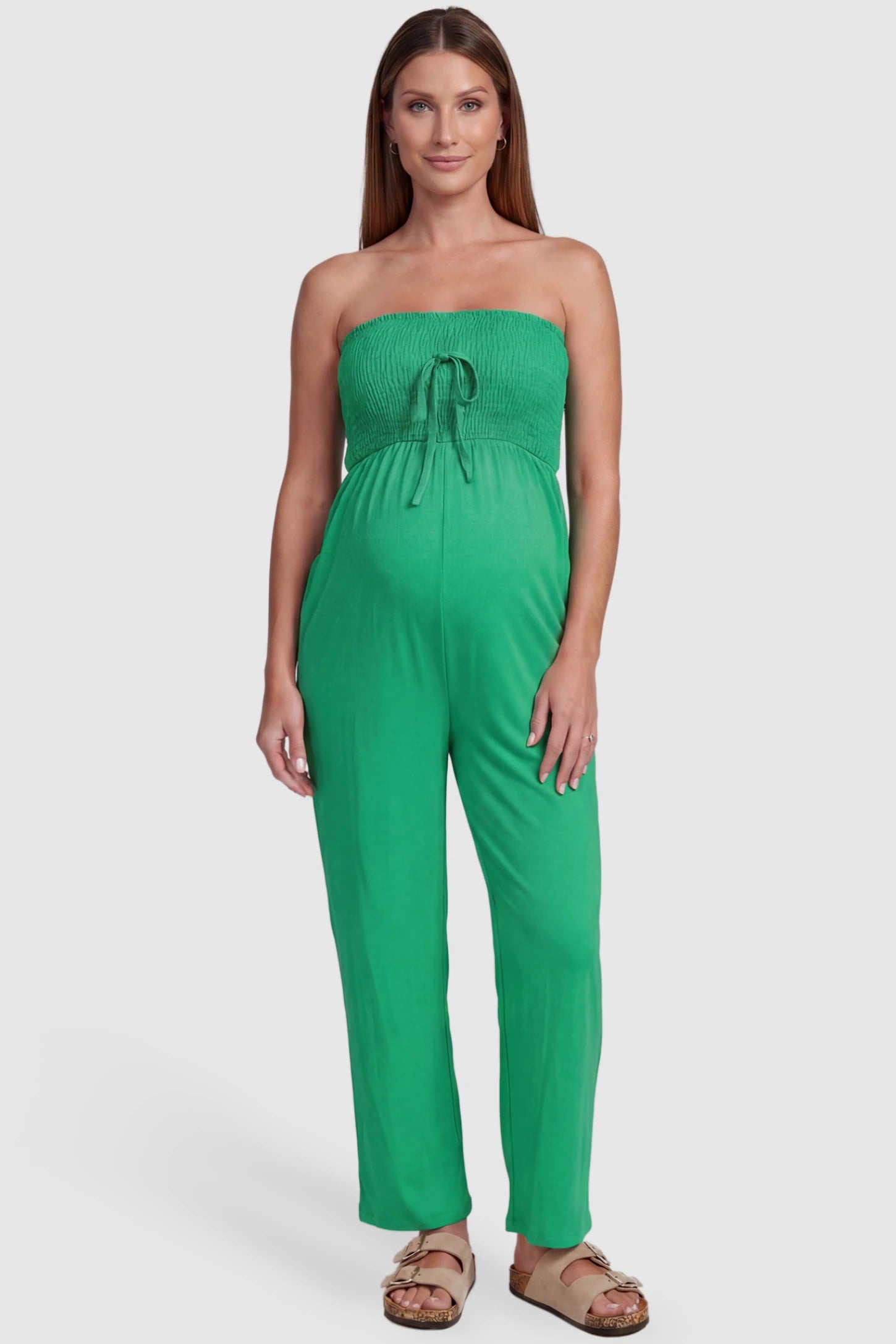 Strapless Smocked Bust Wide Leg Maternity Jumpsuit Strapless Smocked Bust Wide Leg Maternity Jumpsuit in Green featuring a relaxed leg design on a pregnant model, front view.