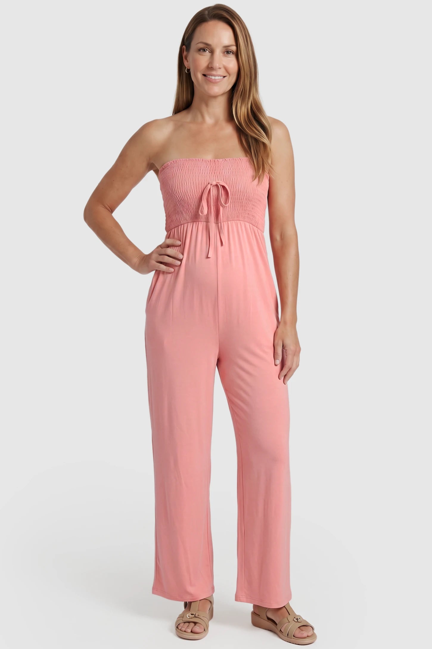Strapless Smocked Bust Wide Leg Maternity Jumpsuit Strapless Smocked Bust Wide Leg Maternity Jumpsuit in Pink featuring a relaxed leg design on a postpartum model, front view.
