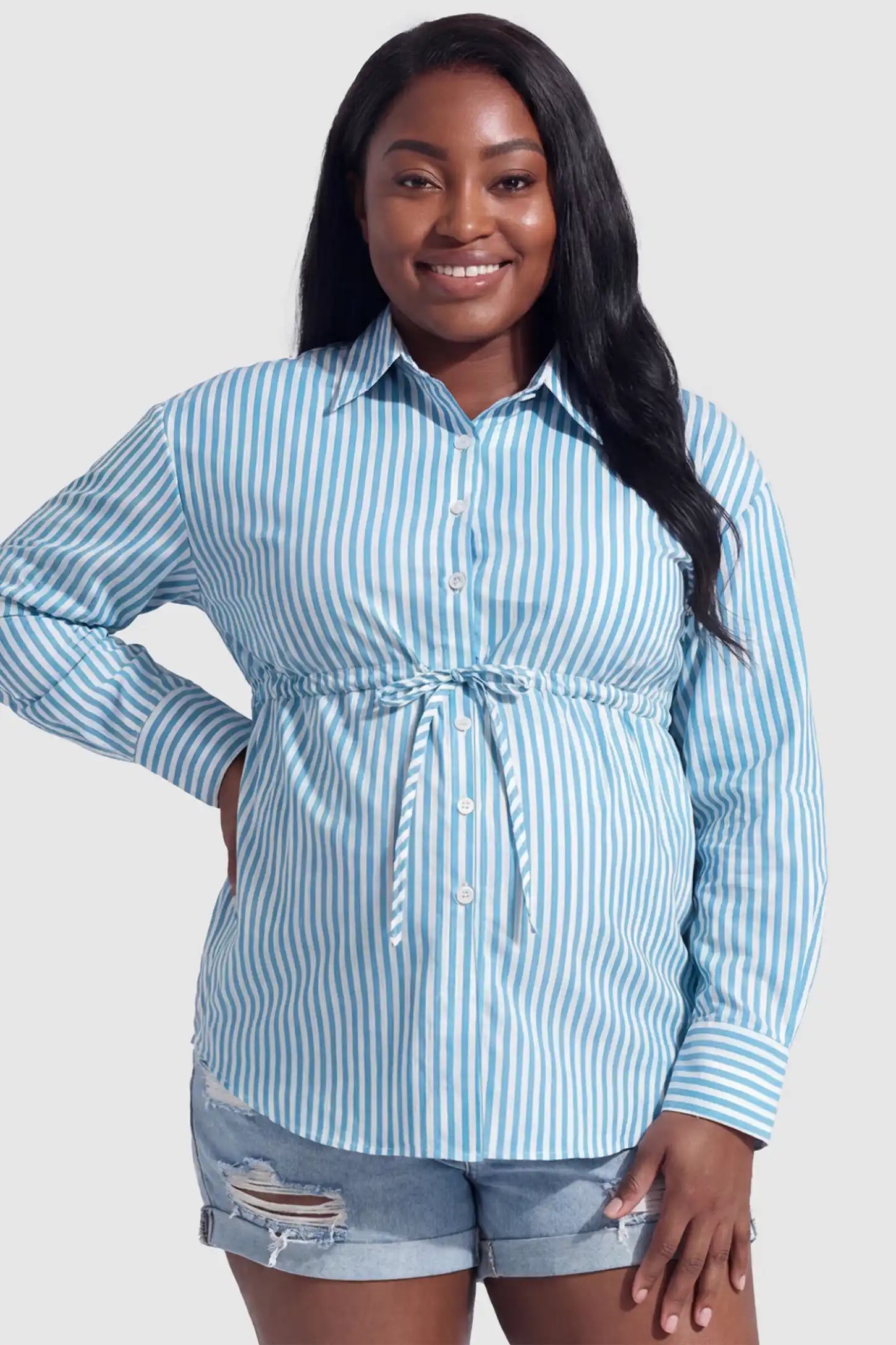 Striped Button Down Collared Neck Maternity Top Striped Button Down Collared Neck Maternity Top in Blue featuring a mid-waist adjustable drawstring on a plus size pregnant model, front view.