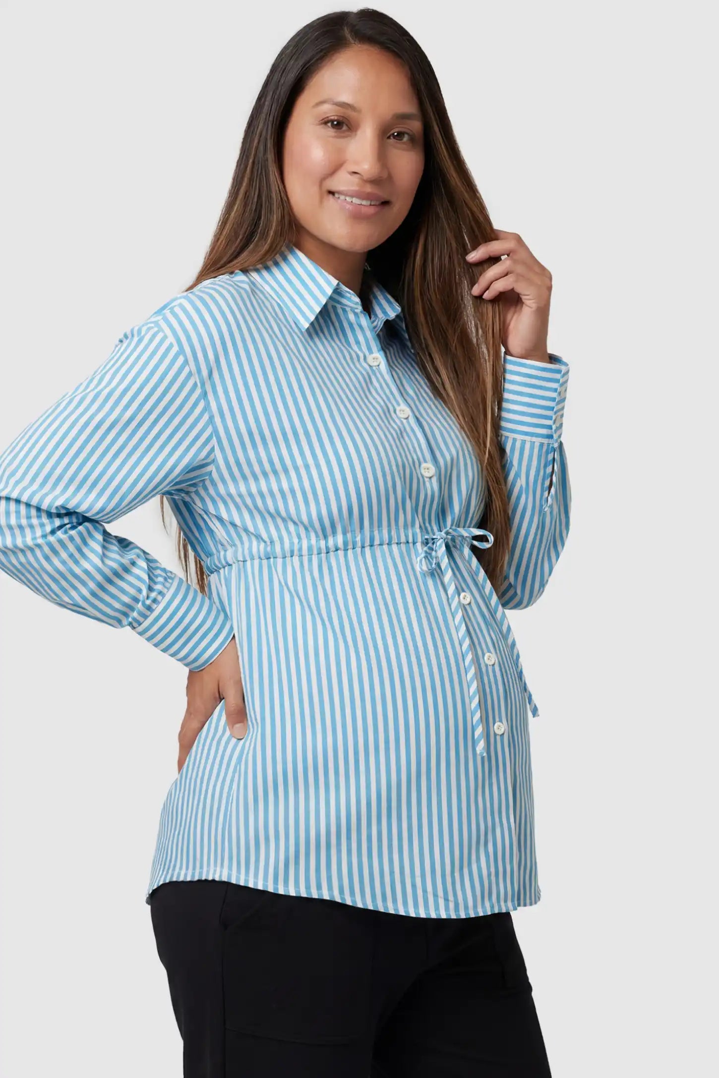 Striped Button Down Collared Neck Maternity Top Striped Button Down Collared Neck Maternity Top in Blue featuring a mid-waist adjustable drawstring on a pregnant model, side view.