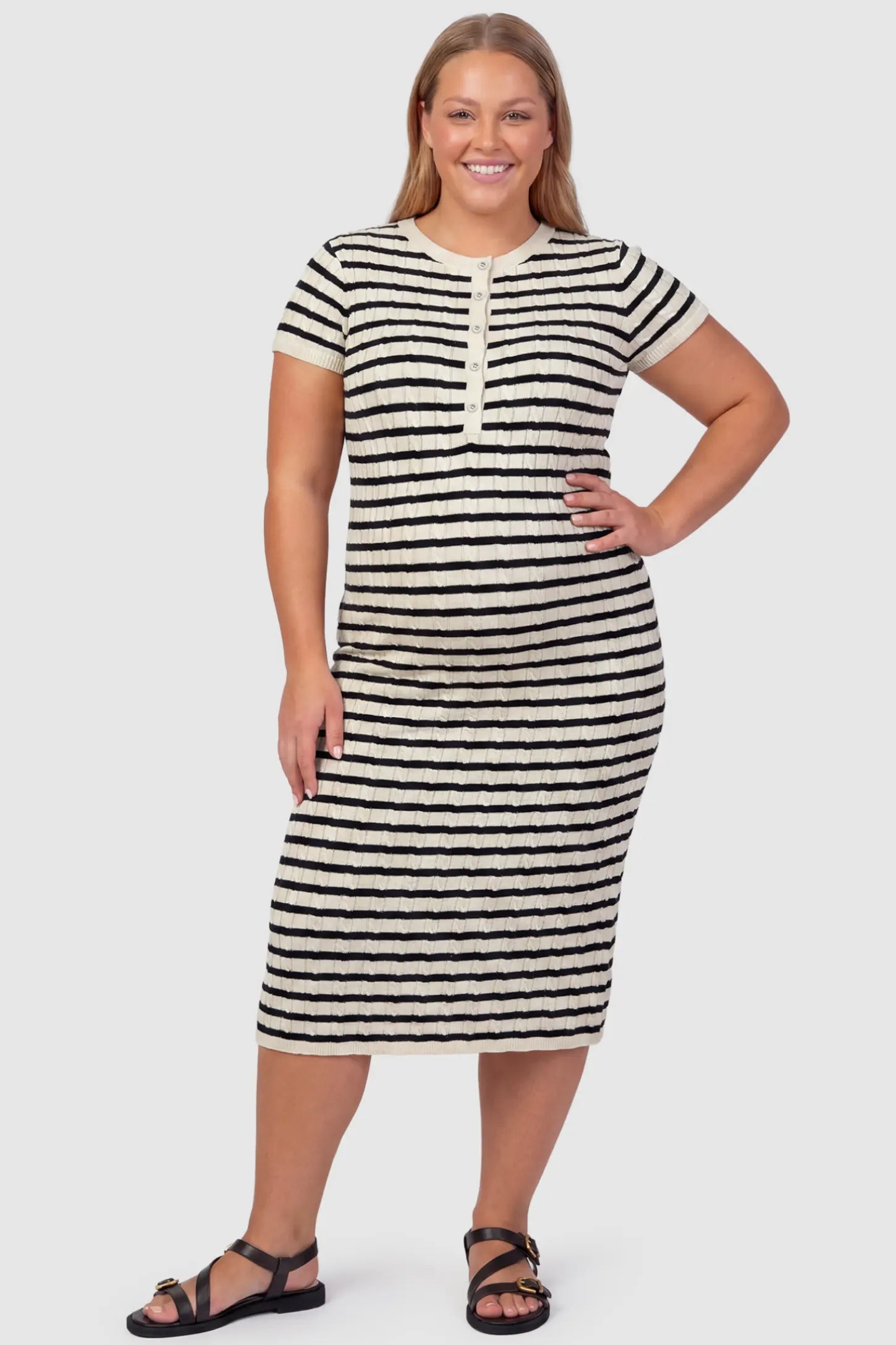 Striped Button Front Short Sleeve Maternity Midi Dress Striped Button Front Short Sleeve Maternity Midi Dress in black stripe featuring short sleeves and a round neck on a plus size pregnant model, front view.