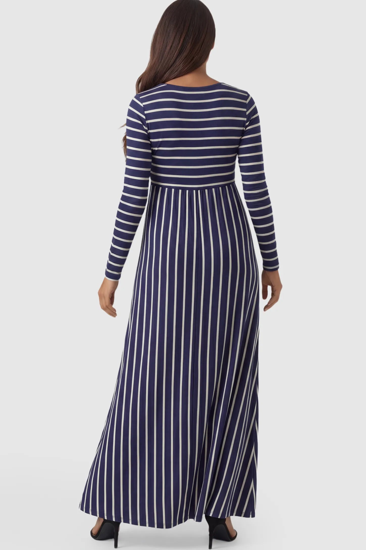 Striped Long Sleeve Maternity Maxi Dress Stretch Jersey Mixed-Stripe Maternity Maxi Dress in dark blue and White featuring an empire waist on a pregnant model showing back.