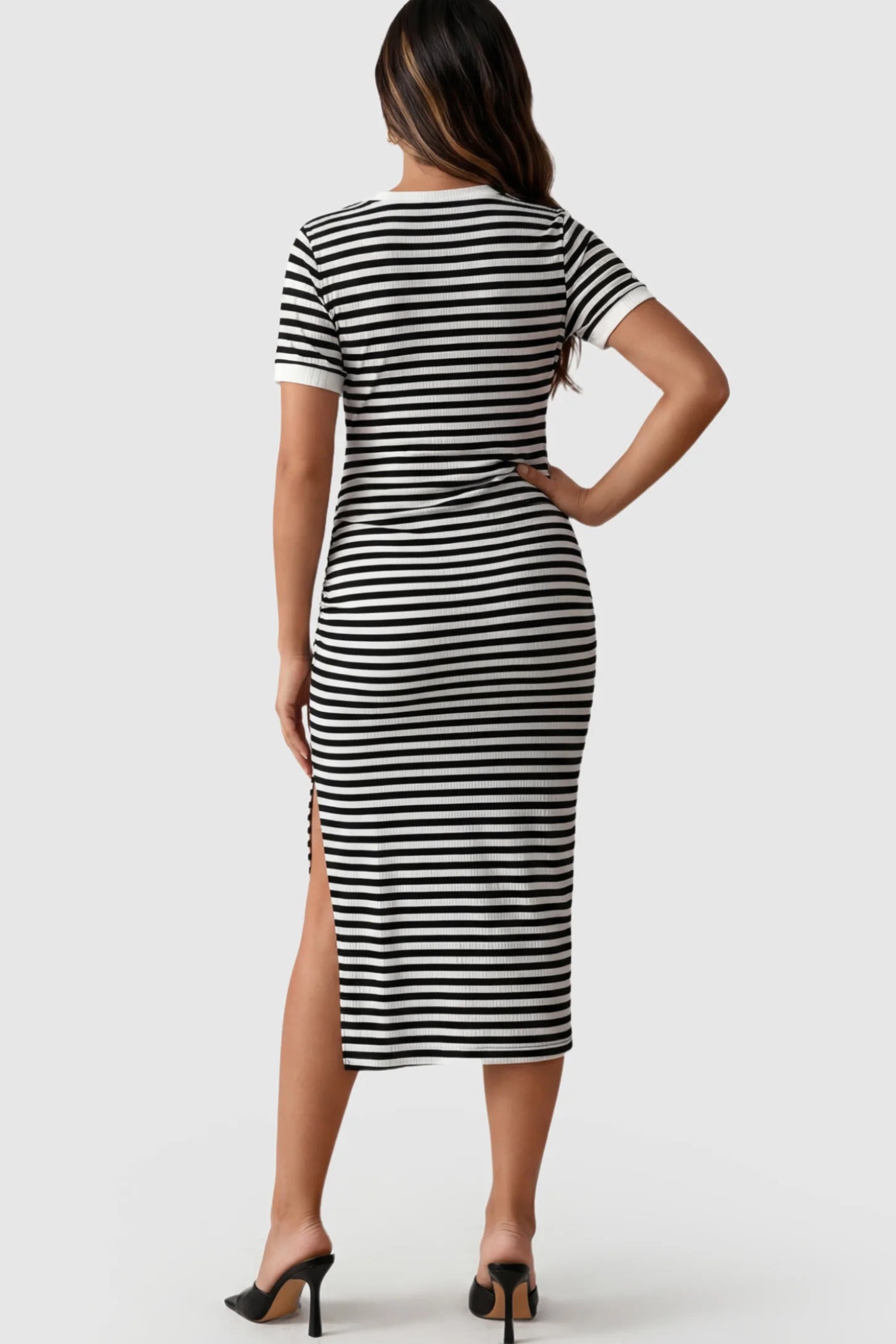 Striped Side-Slit Bodycon Maternity Midi Dress Striped Side-Slit Bodycon Maternity Midi Dress in Black and White featuring a side slit on a pregnant model showing back.