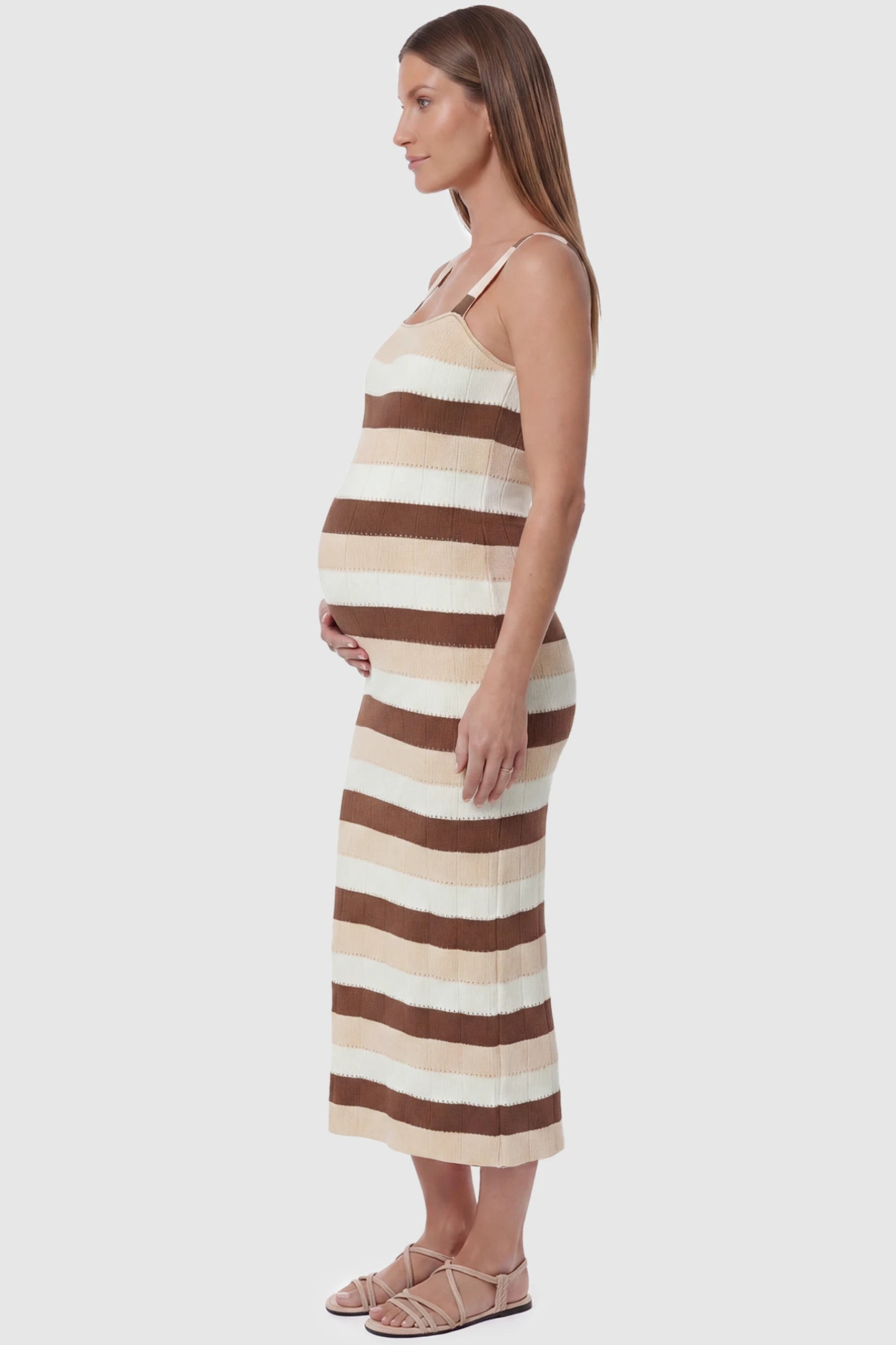 Striped Square Neck Sleeveless Maternity Midi Dress Striped Square Neck Sleeveless Maternity Midi Dress in Brown featuring adjustable slider straps and soft knit stretch on a pregnant model, side view.