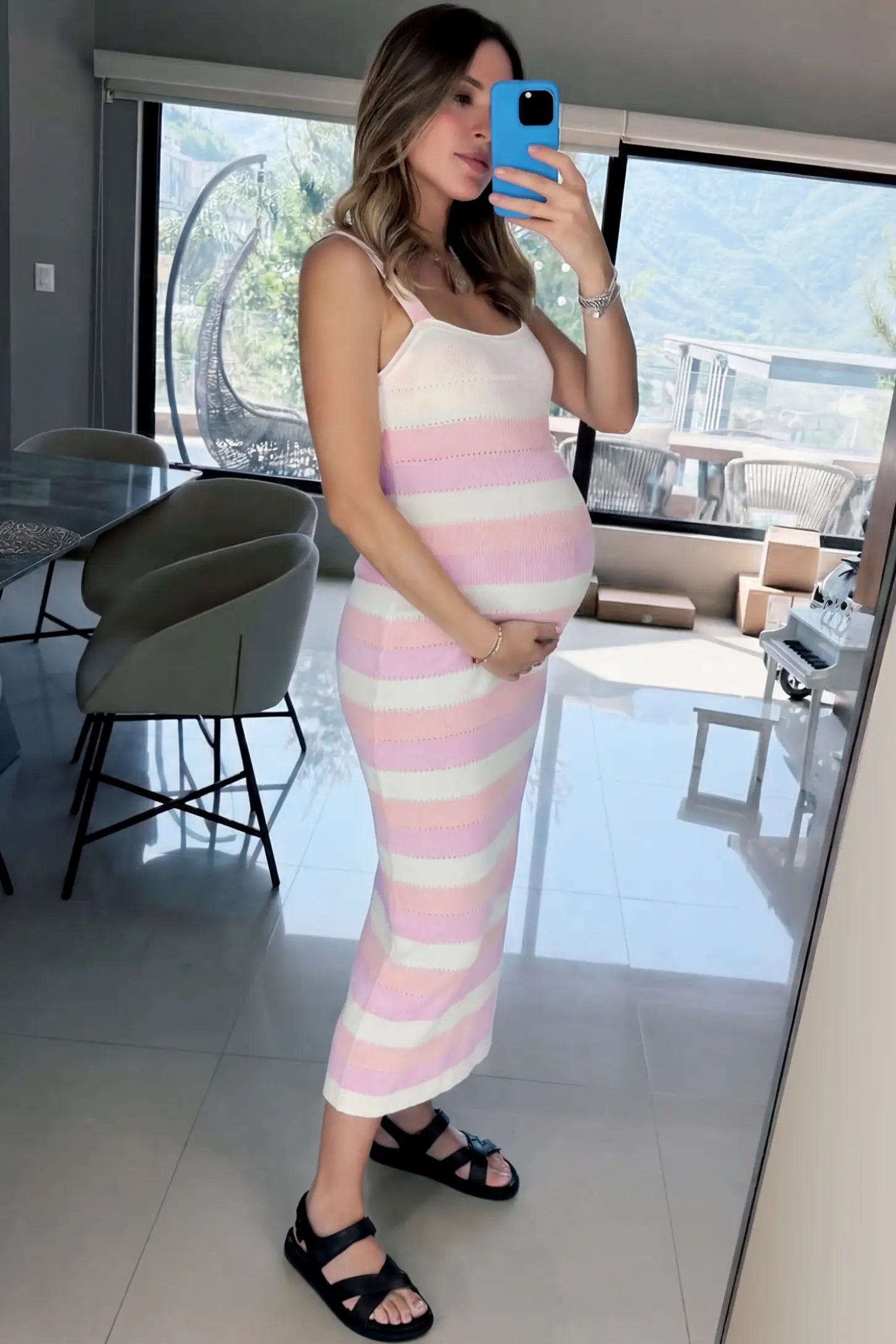 Striped Square Neck Sleeveless Maternity Midi Dress Striped Square Neck Sleeveless Maternity Midi Dress in Pink featuring adjustable slider straps and soft knit stretch on a pregnant model in indoor setting, side view.